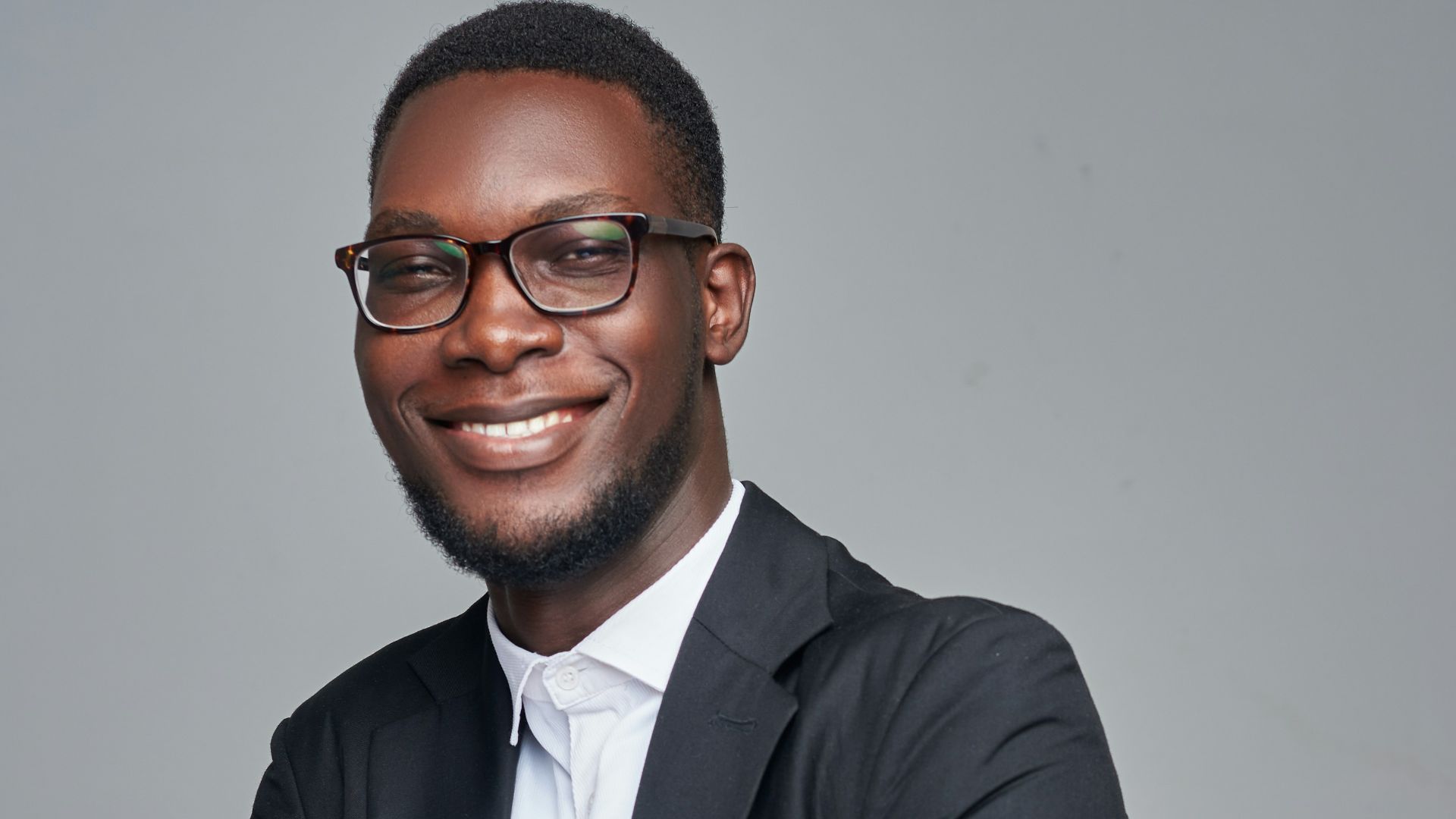a man in a suit and glasses posing for a picture