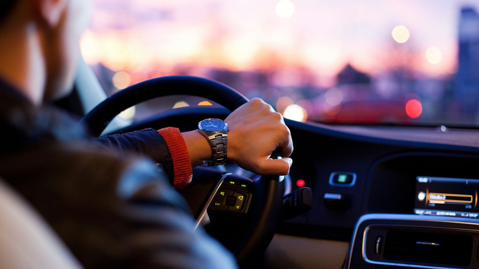 man driving a car wearing wrist watch