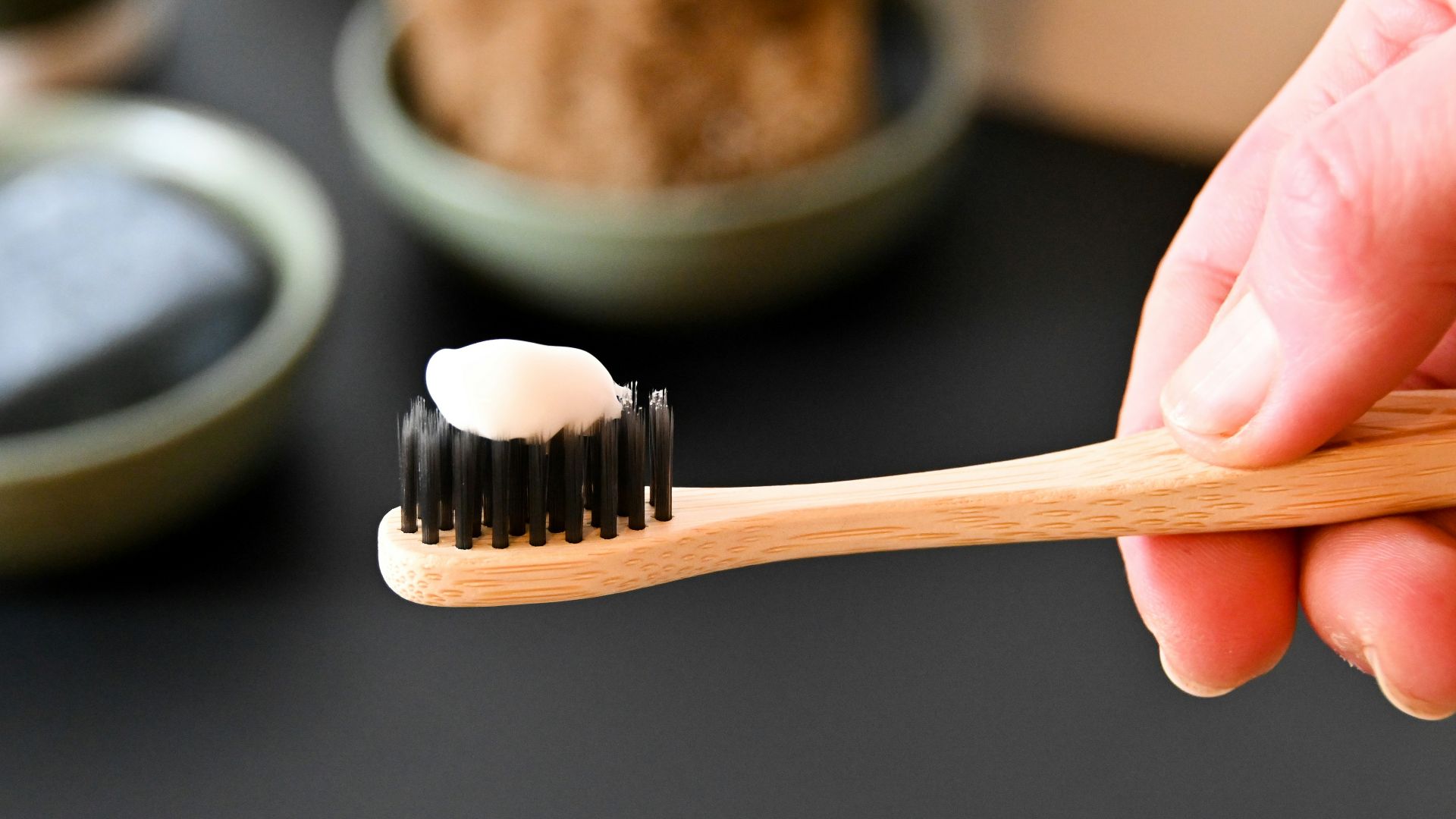 a person holding a toothbrush with a toothpaste on it