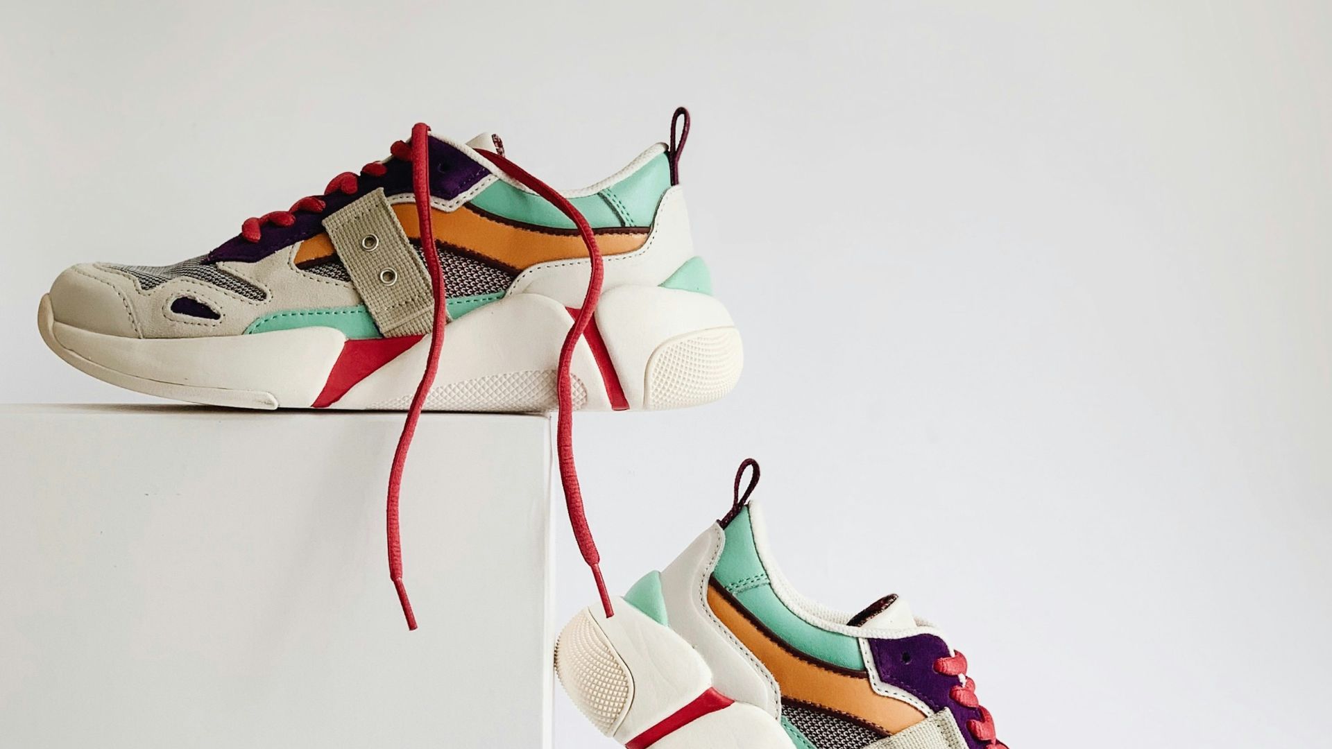 pair of white-and-orange athletic shoes on white box