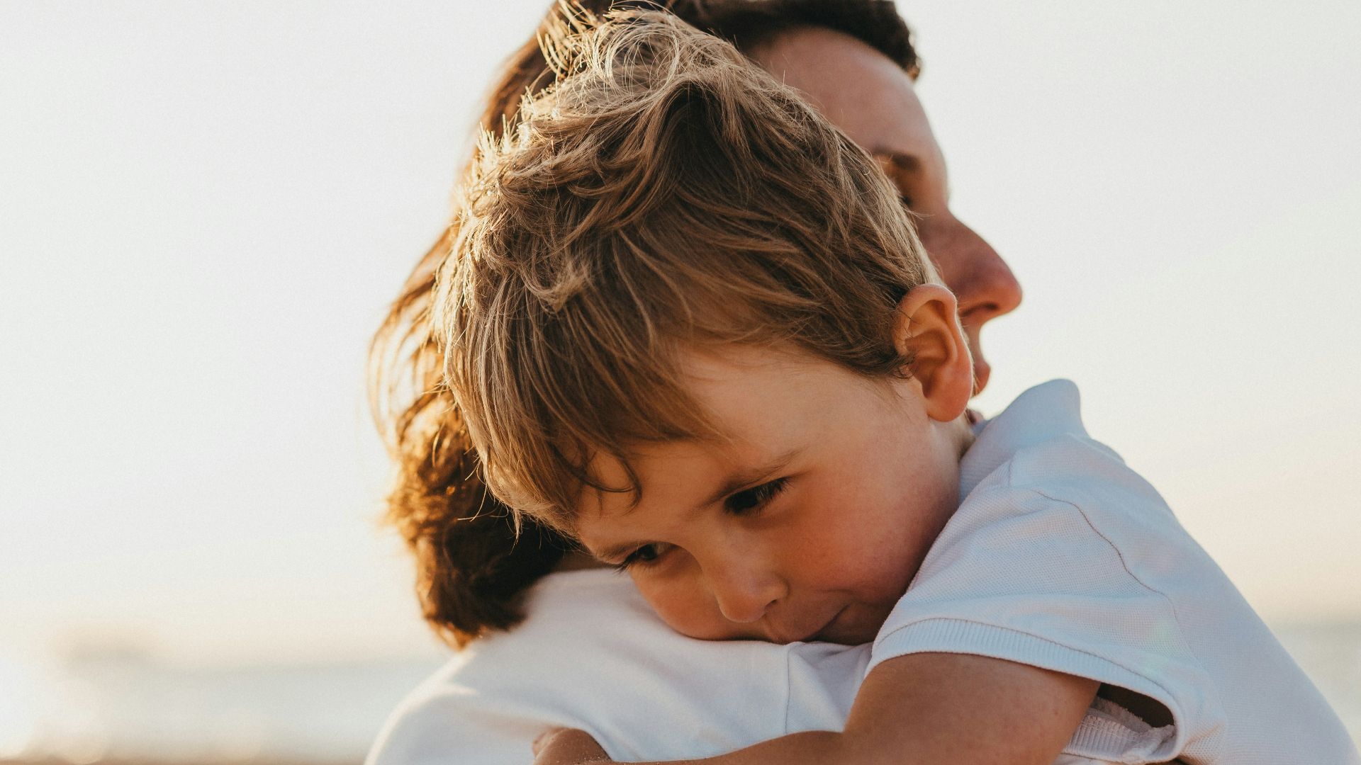 boy hugging woman during daytime