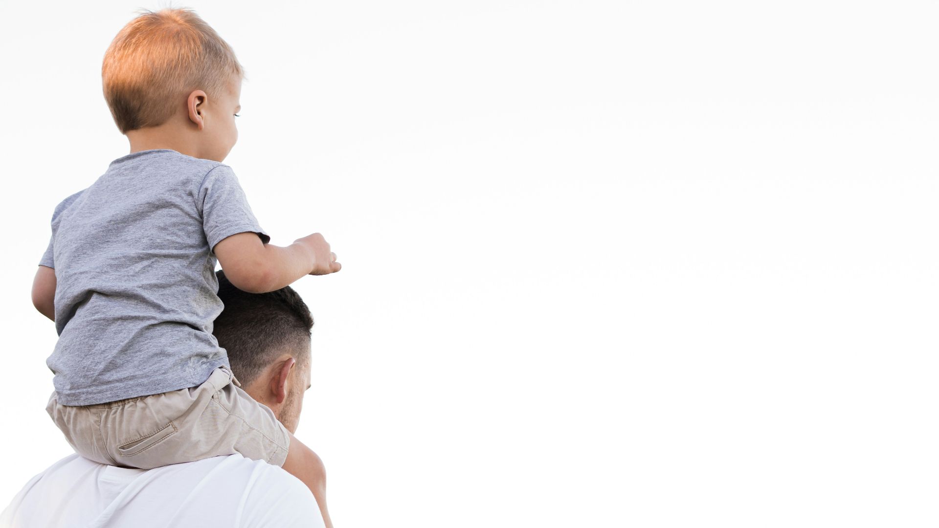 man in white shirt carrying boy