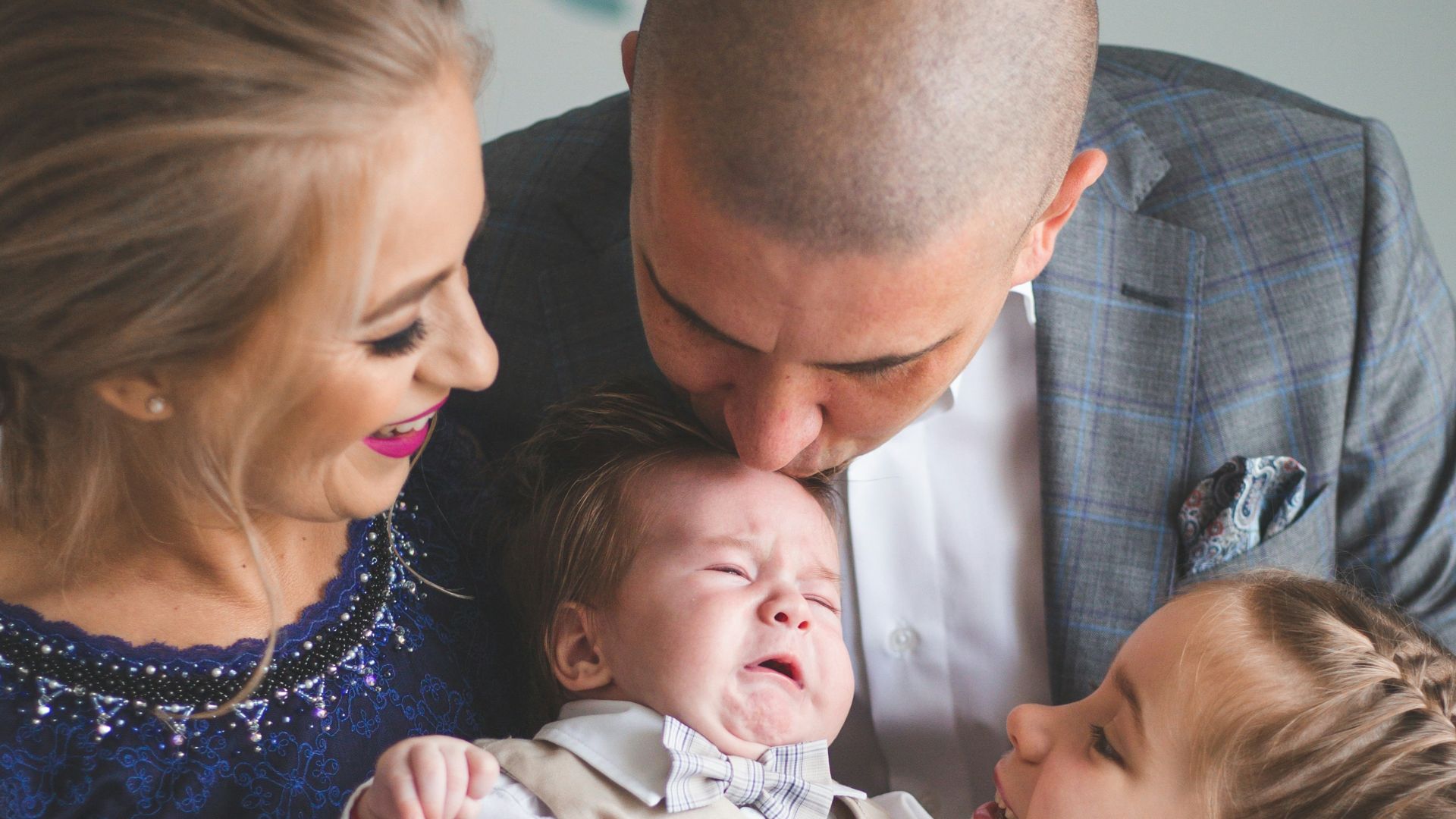 a man and two women holding a baby