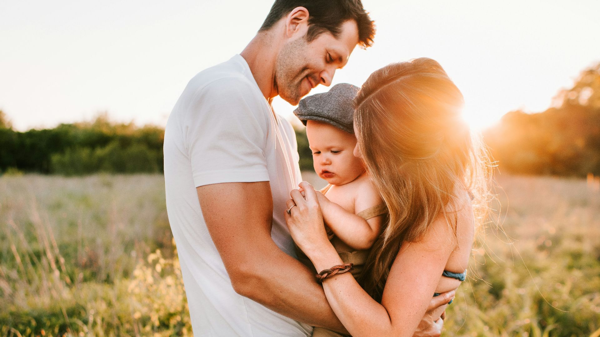 family photo on green grass during golden hour