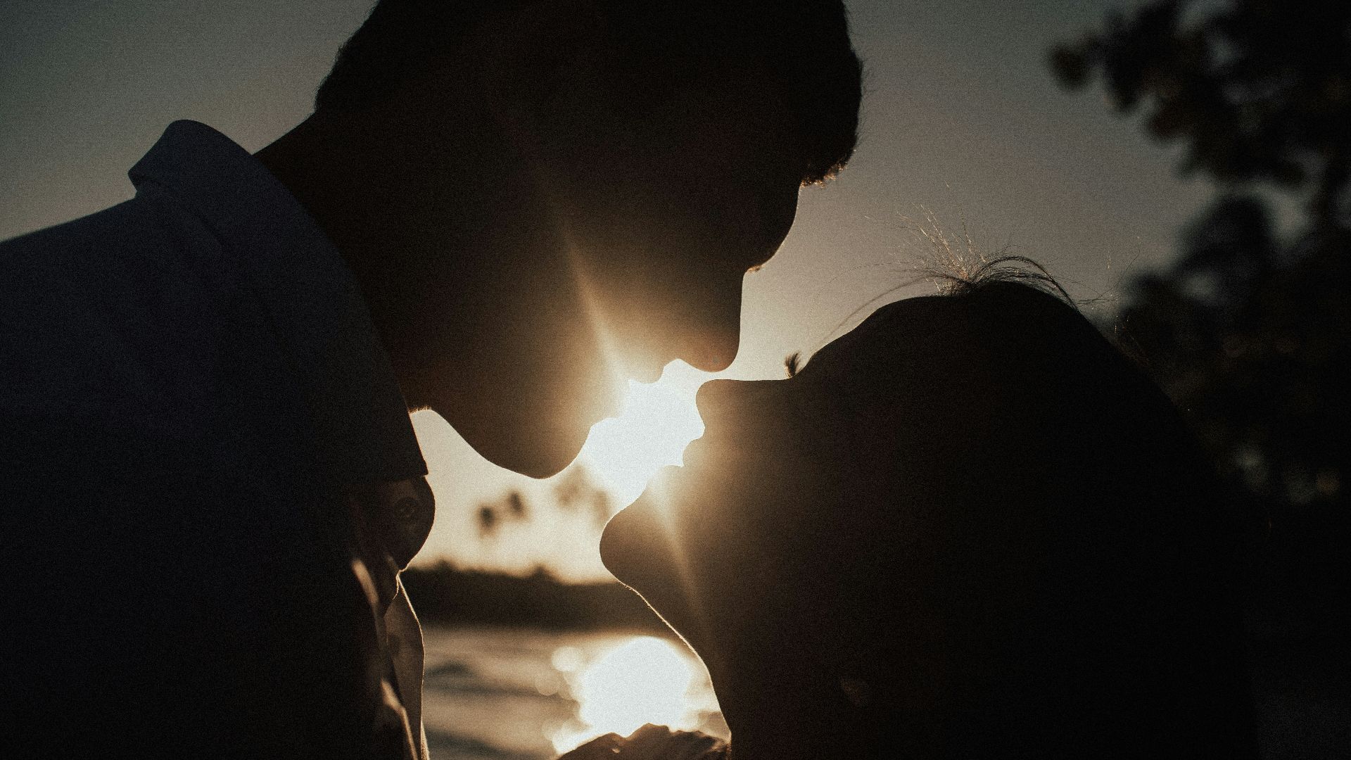silhouette of couple kissing during sunset