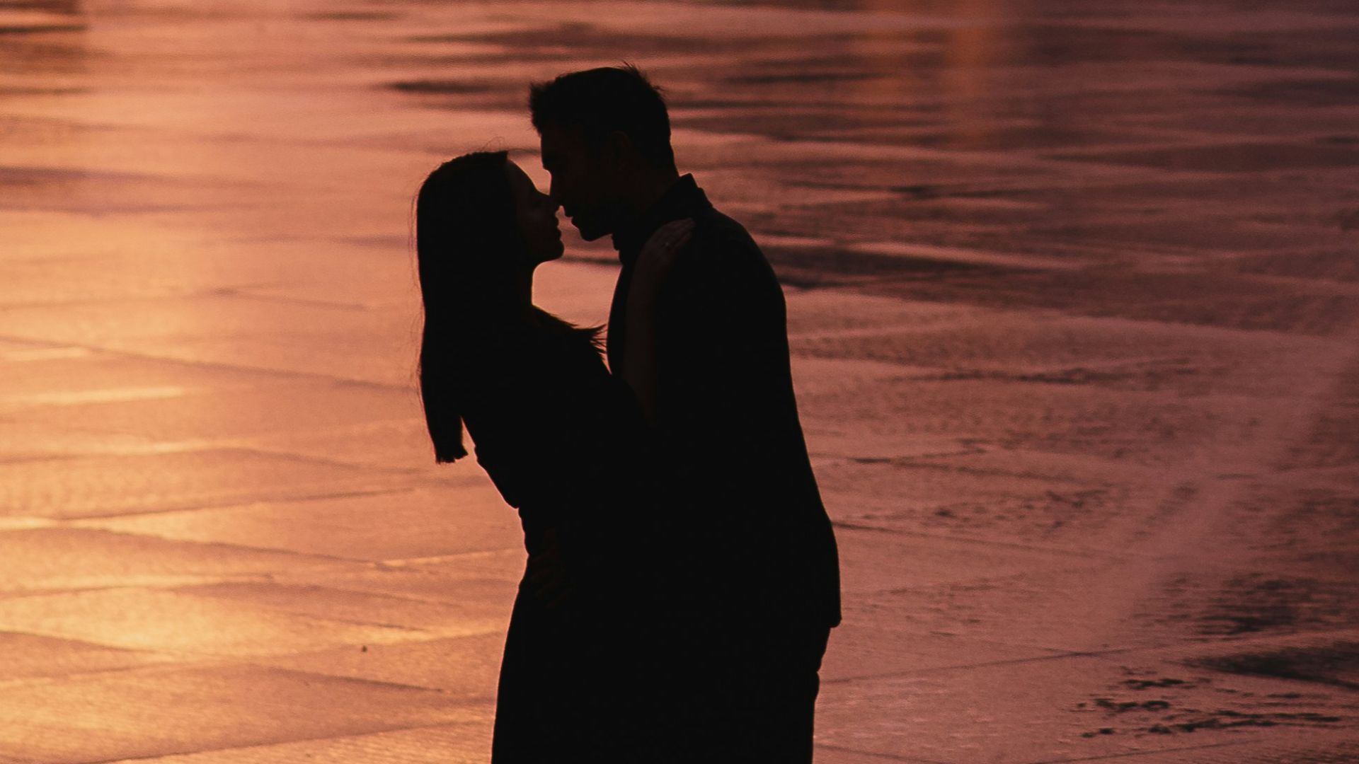 a couple kissing in front of a pyramid