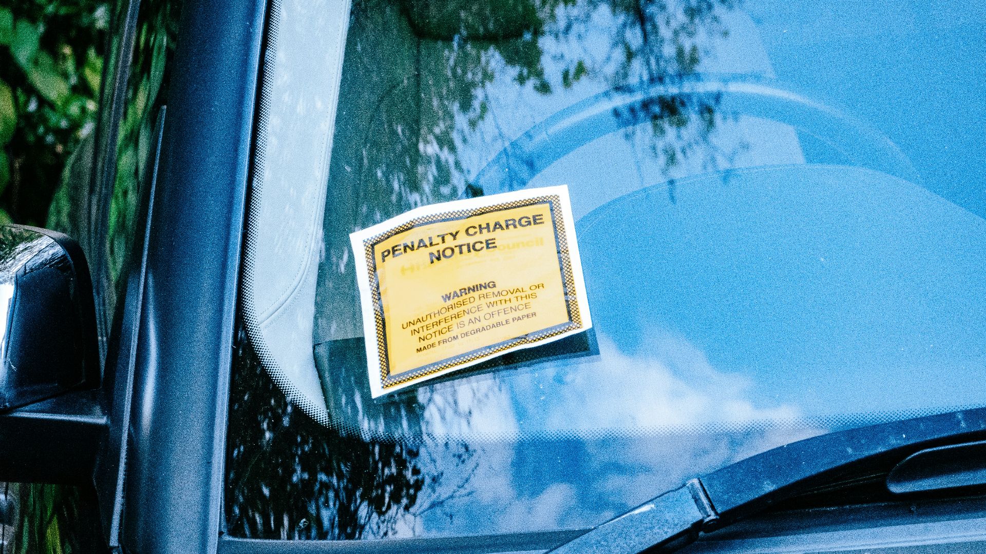 a car with a yellow sign attached to it's side window