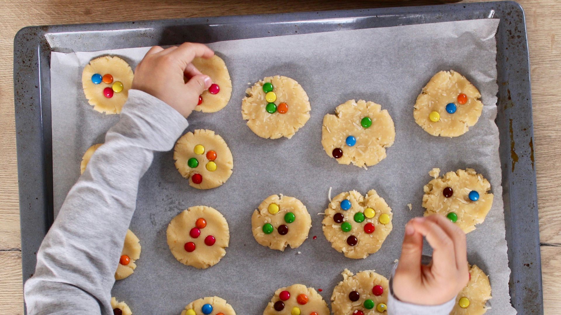 girl in white long sleeve shirt holding brown wooden tray with yellow and white donuts