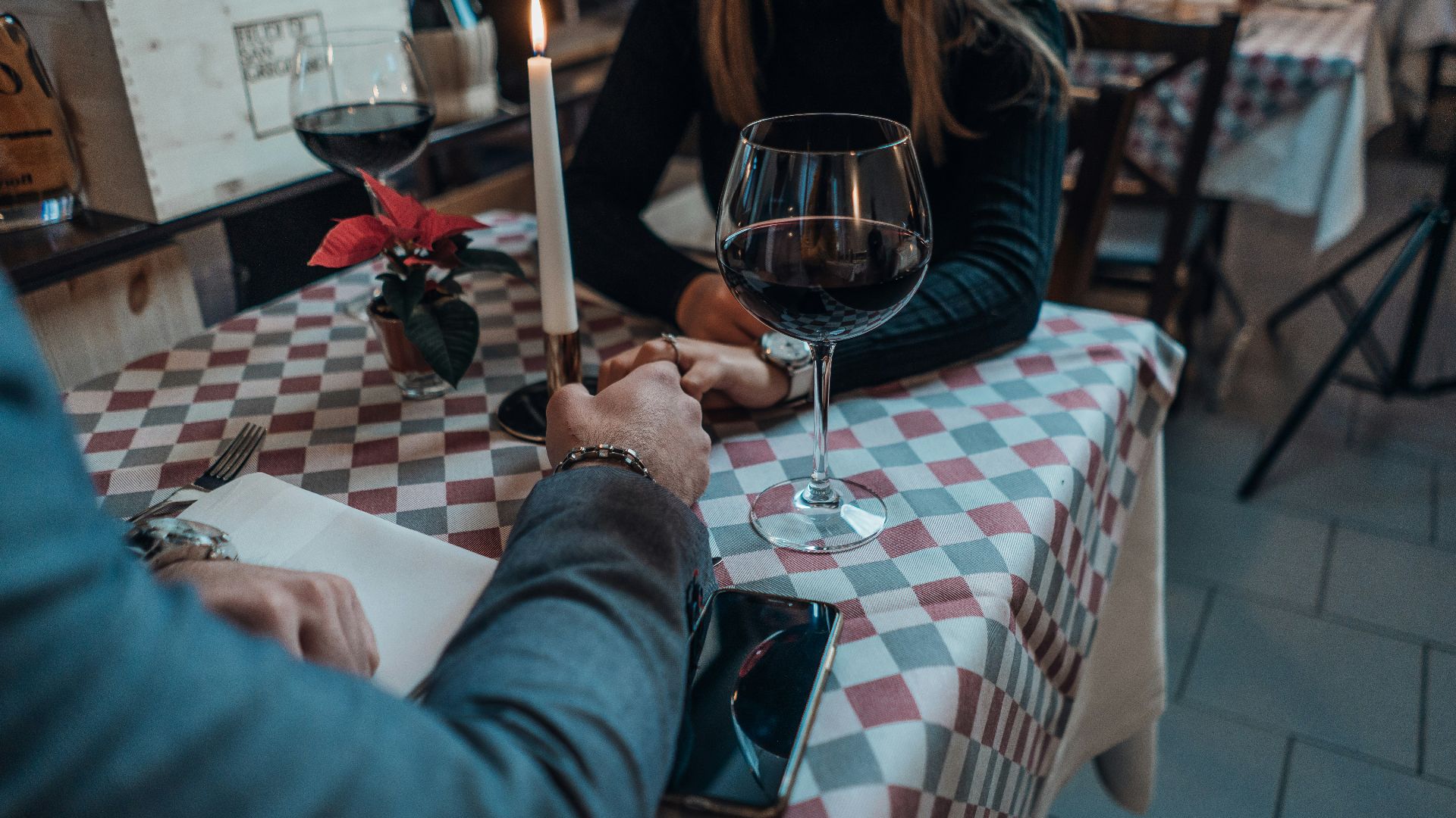 woman wearing black sweater holding hand with man wearing gray suit jacket