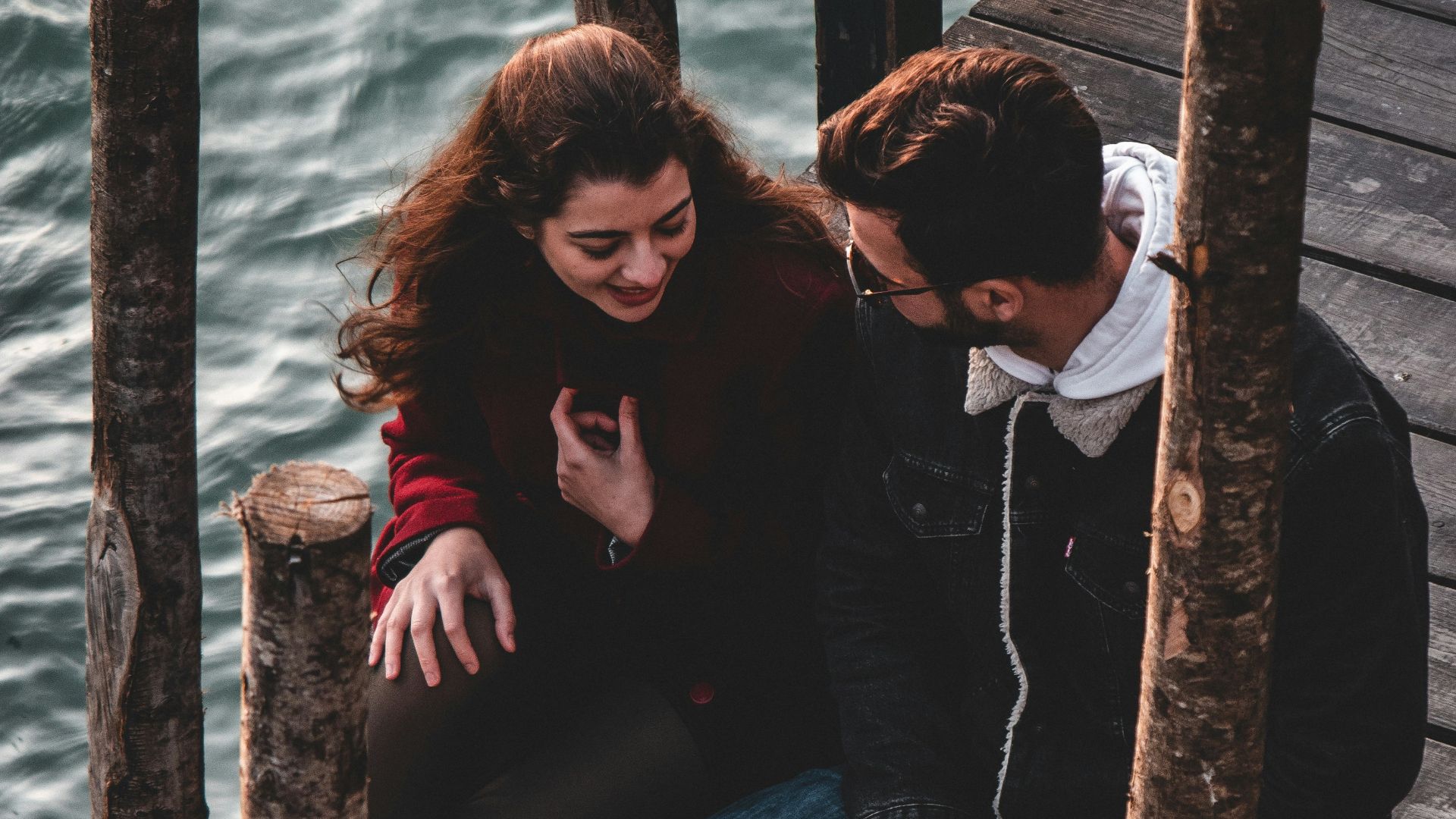 a man and a woman sitting on a dock