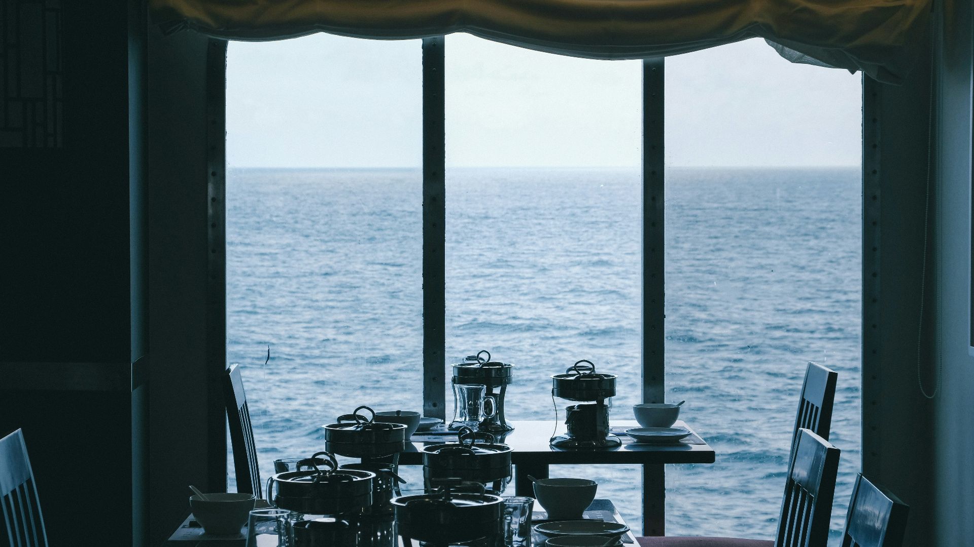 a dining room table with a view of the ocean