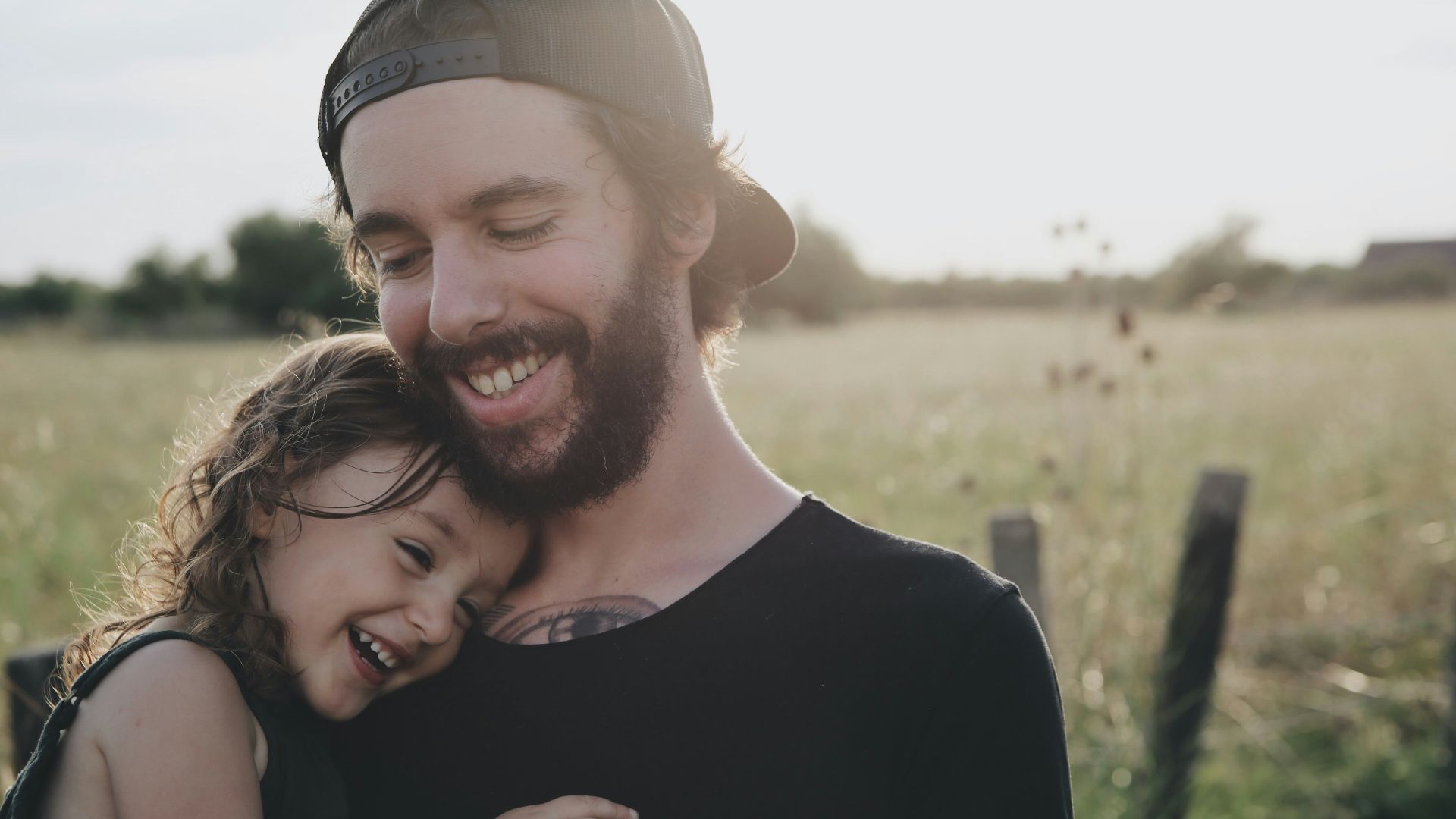 man carrying daughter in black sleeveless top