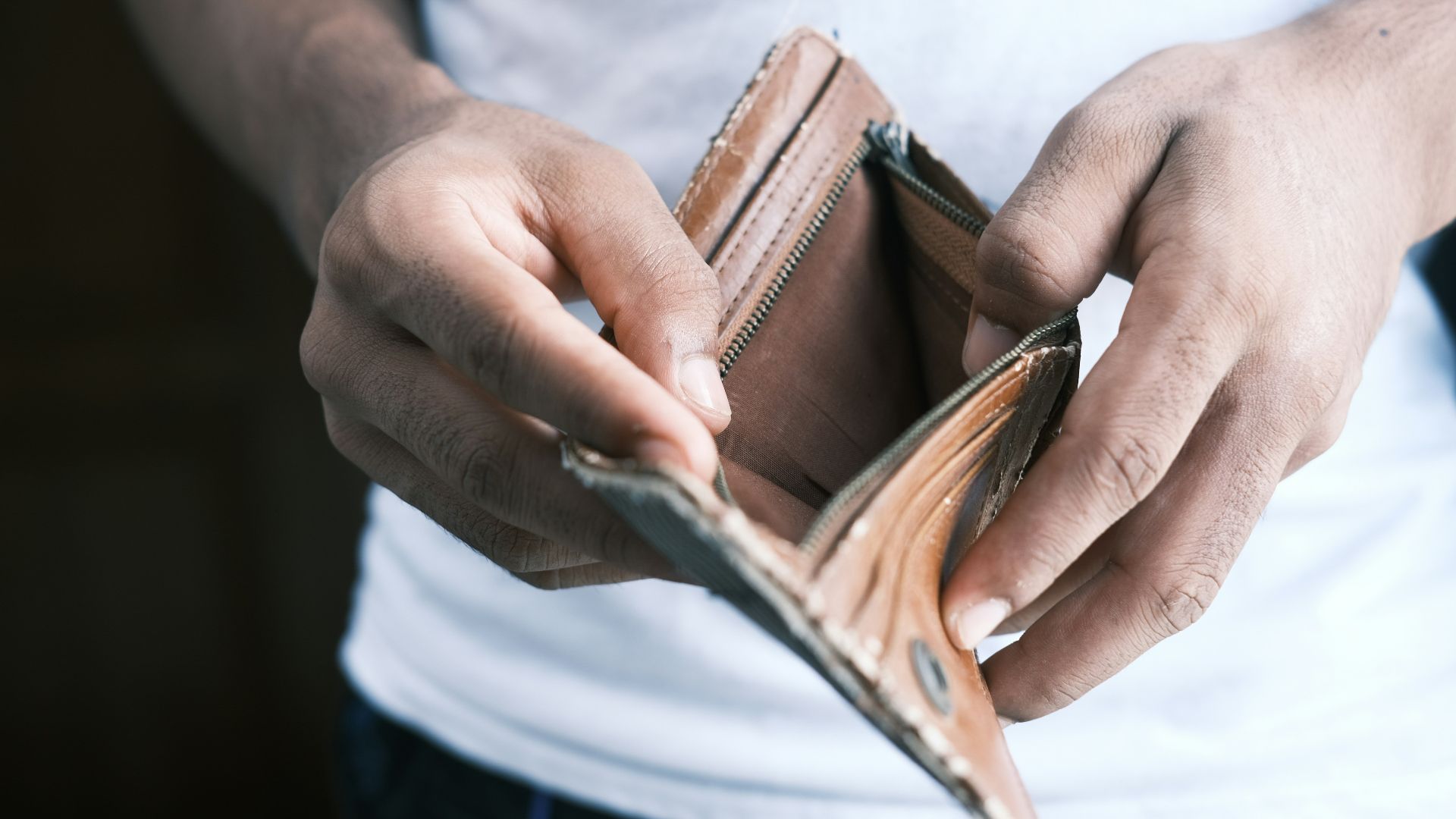 person holding brown leather bifold wallet