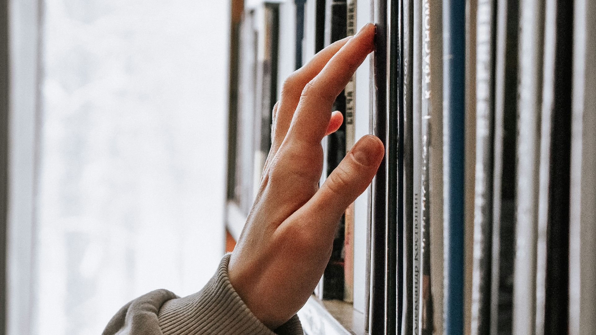person in white long sleeve shirt holding white book