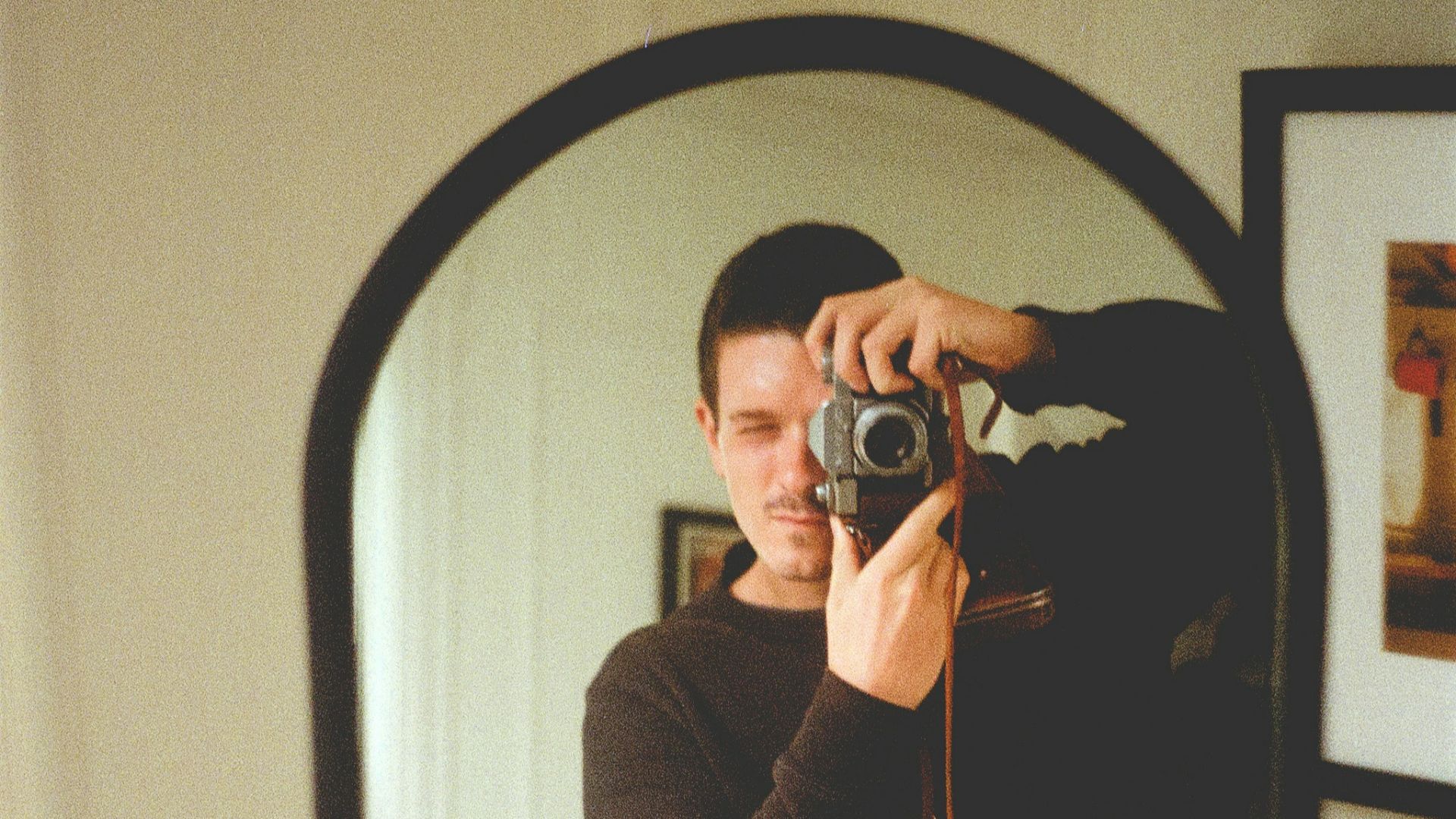 woman in brown jacket taking photo in front of mirror
