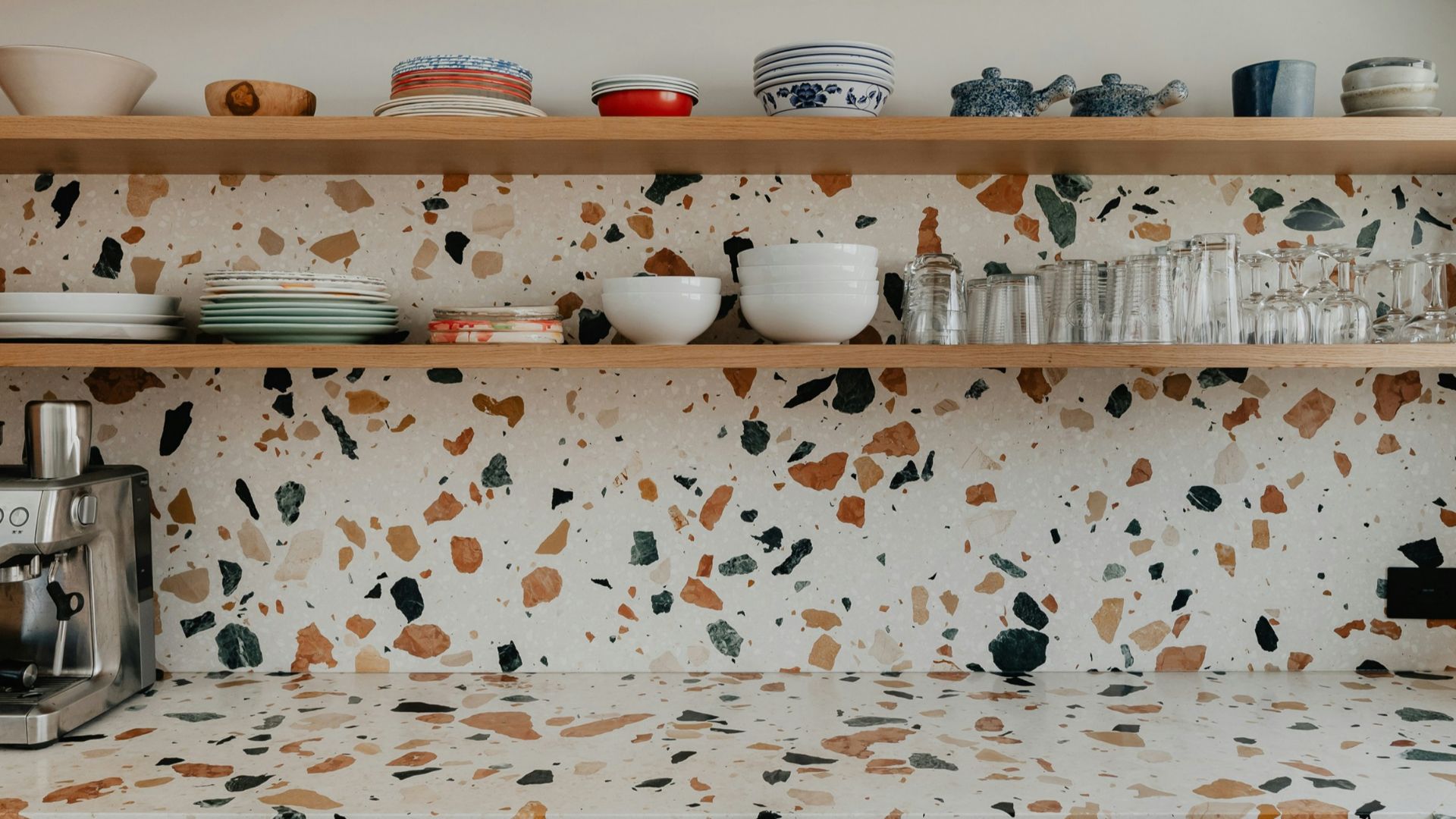 a kitchen counter with a coffee maker and cups on it
