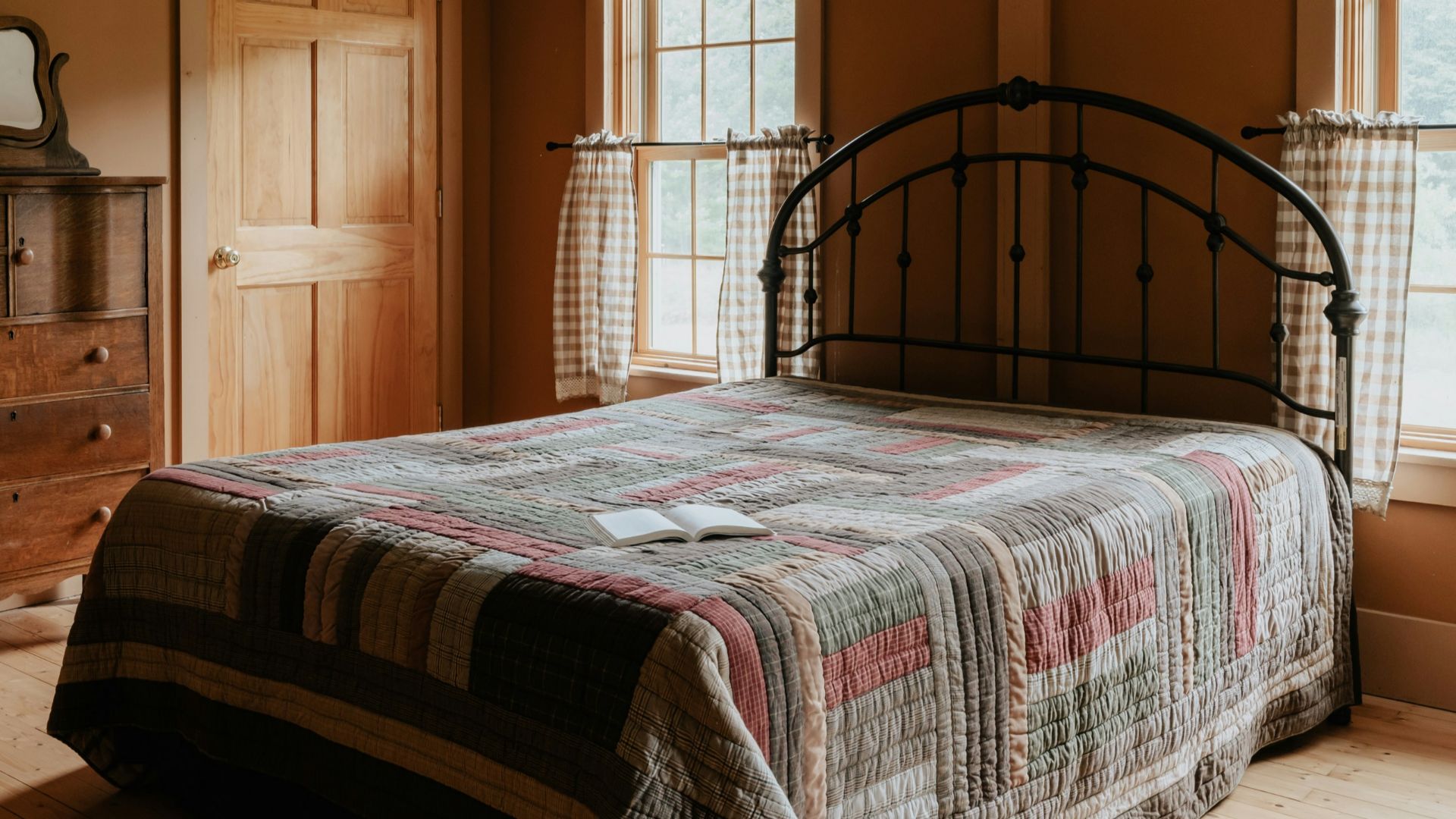 A bed sitting in a bedroom next to two windows