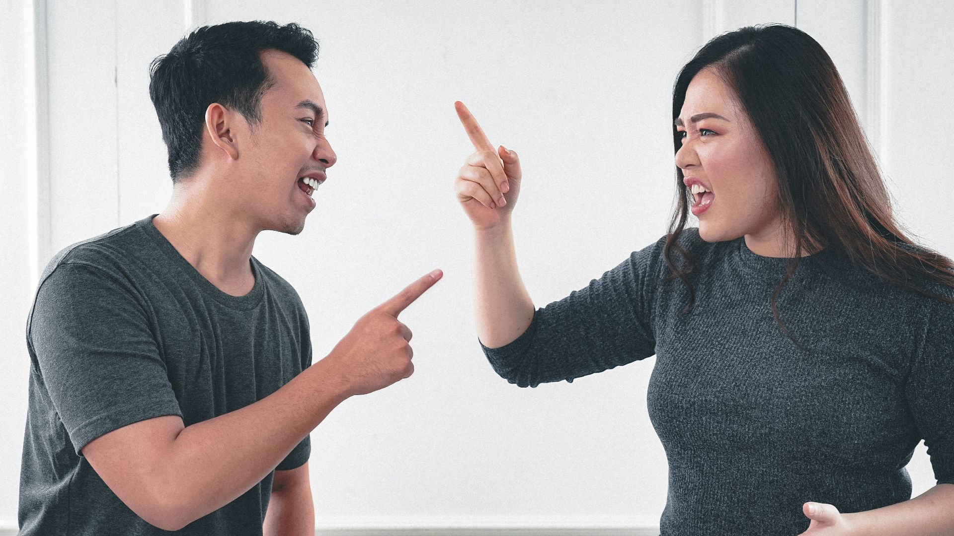 man in gray crew neck long sleeve shirt standing beside woman in black crew neck shirt