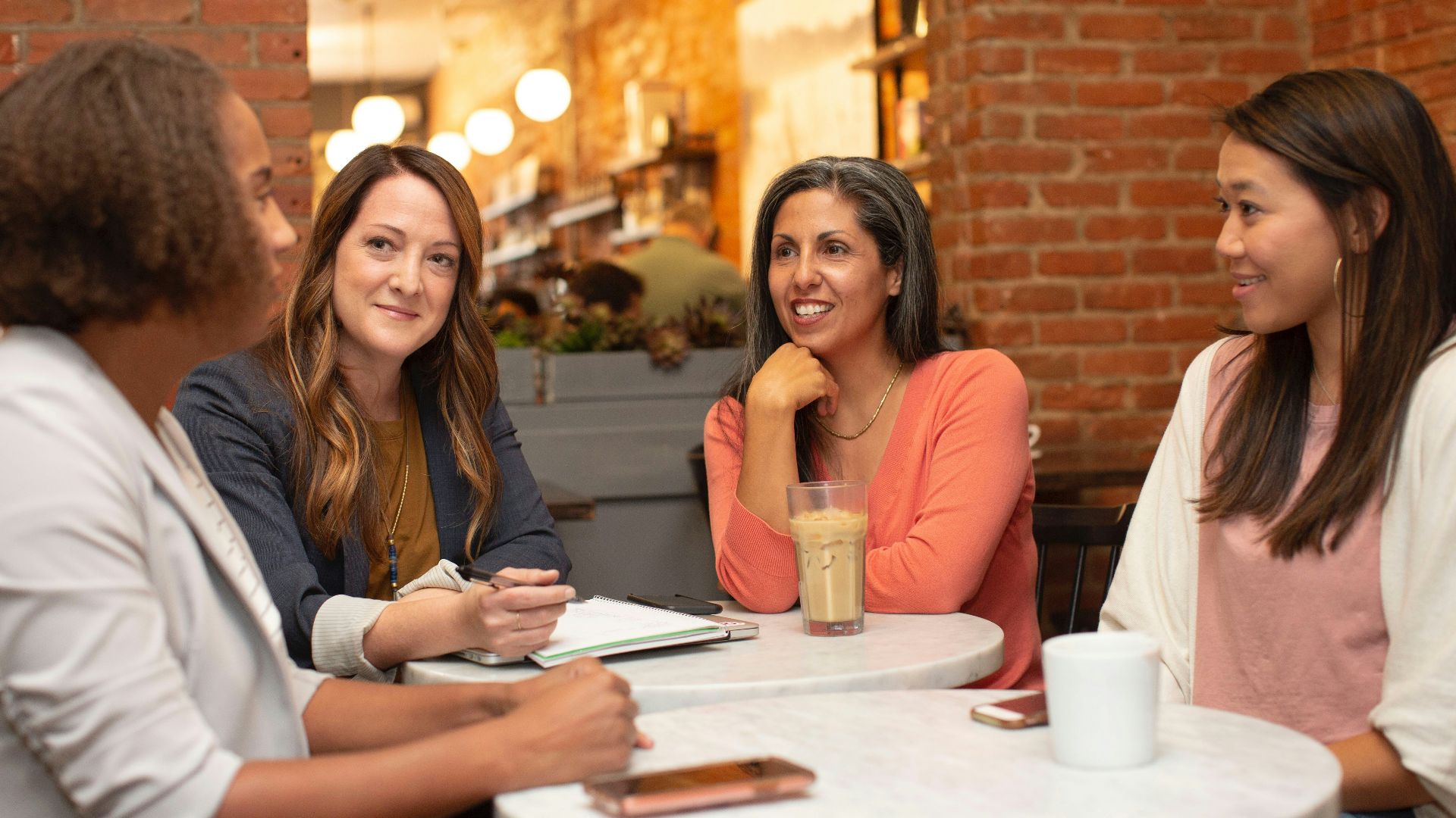 woman in black jacket sitting beside woman in white blazer