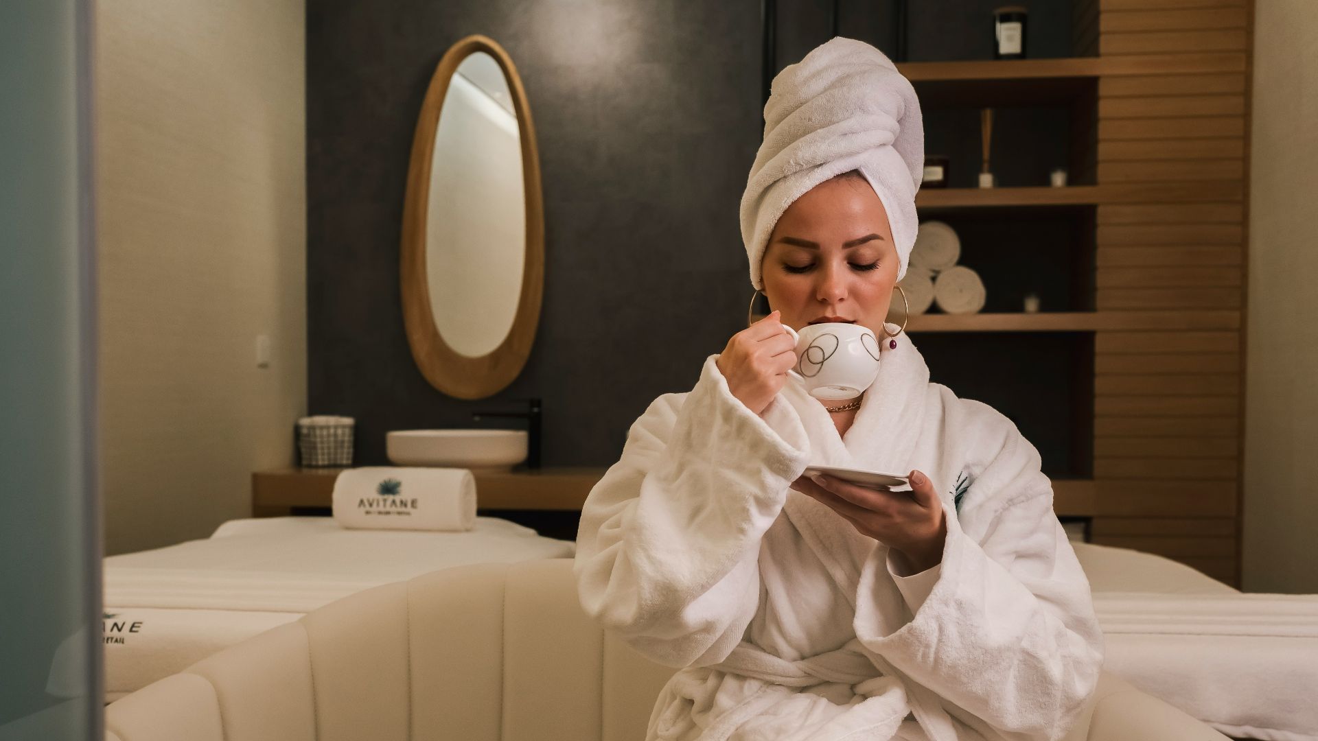 woman in white robe sitting on white couch