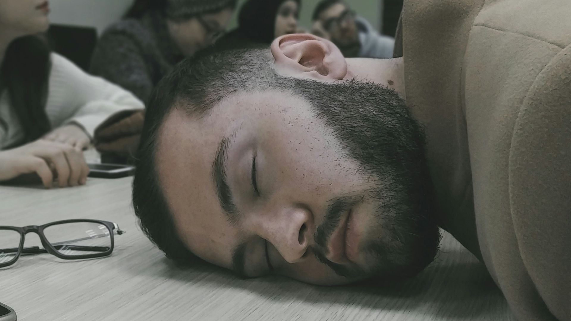 a man laying on a table with his head on the table