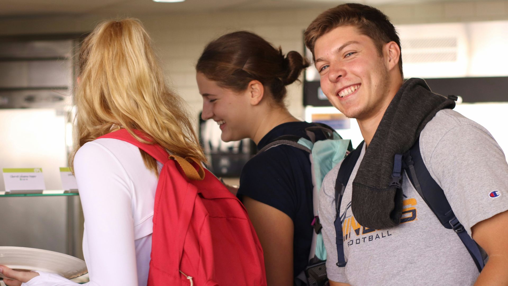 woman in red and white jacket beside man in gray crew neck t-shirt