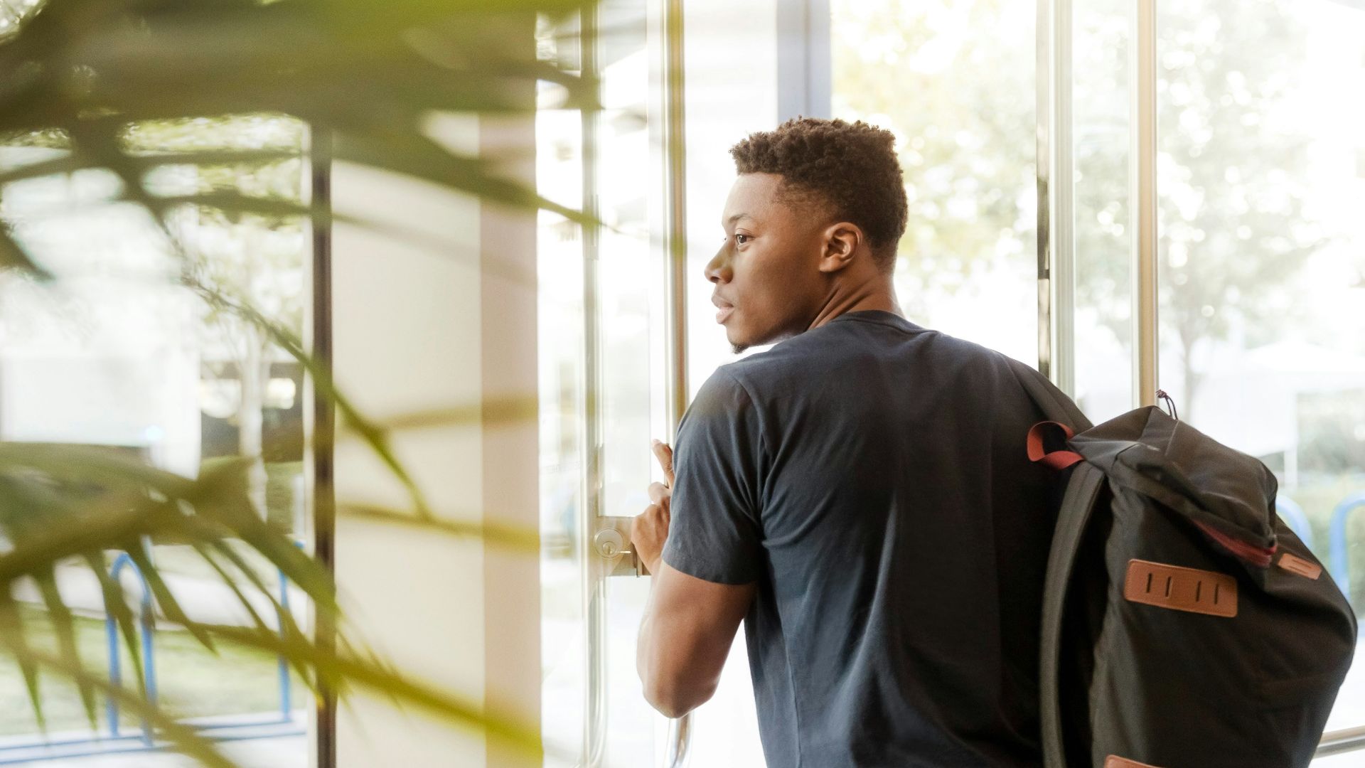 man holding glass door