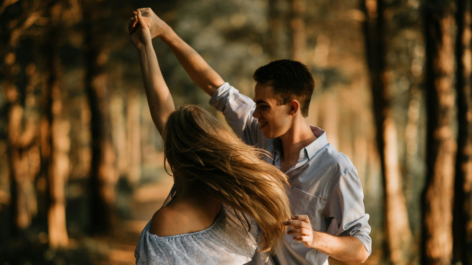 man and woman dancing at center of trees