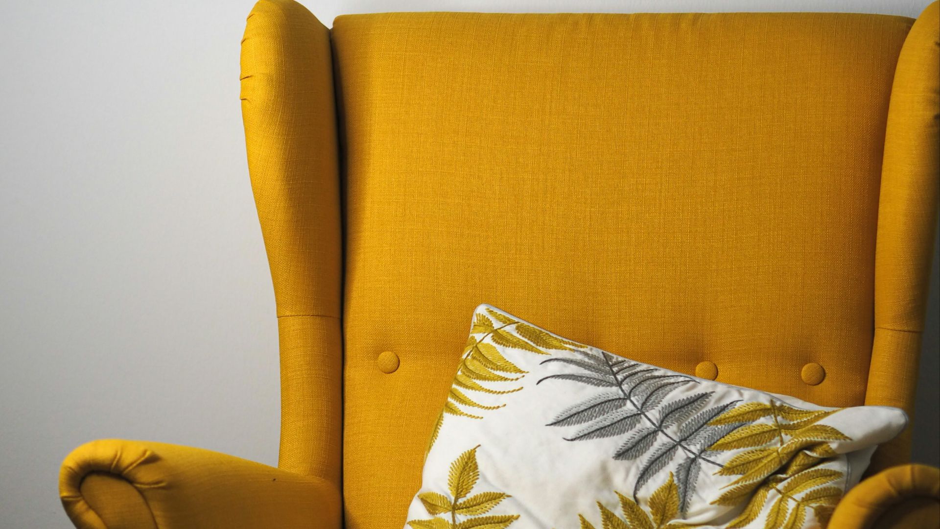 a yellow chair with a pillow on top of it