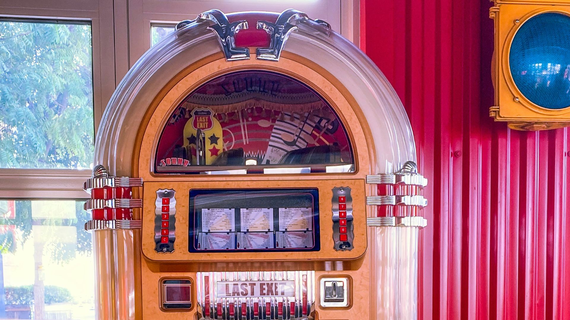 a jukebox sitting in front of a window next to a traffic light