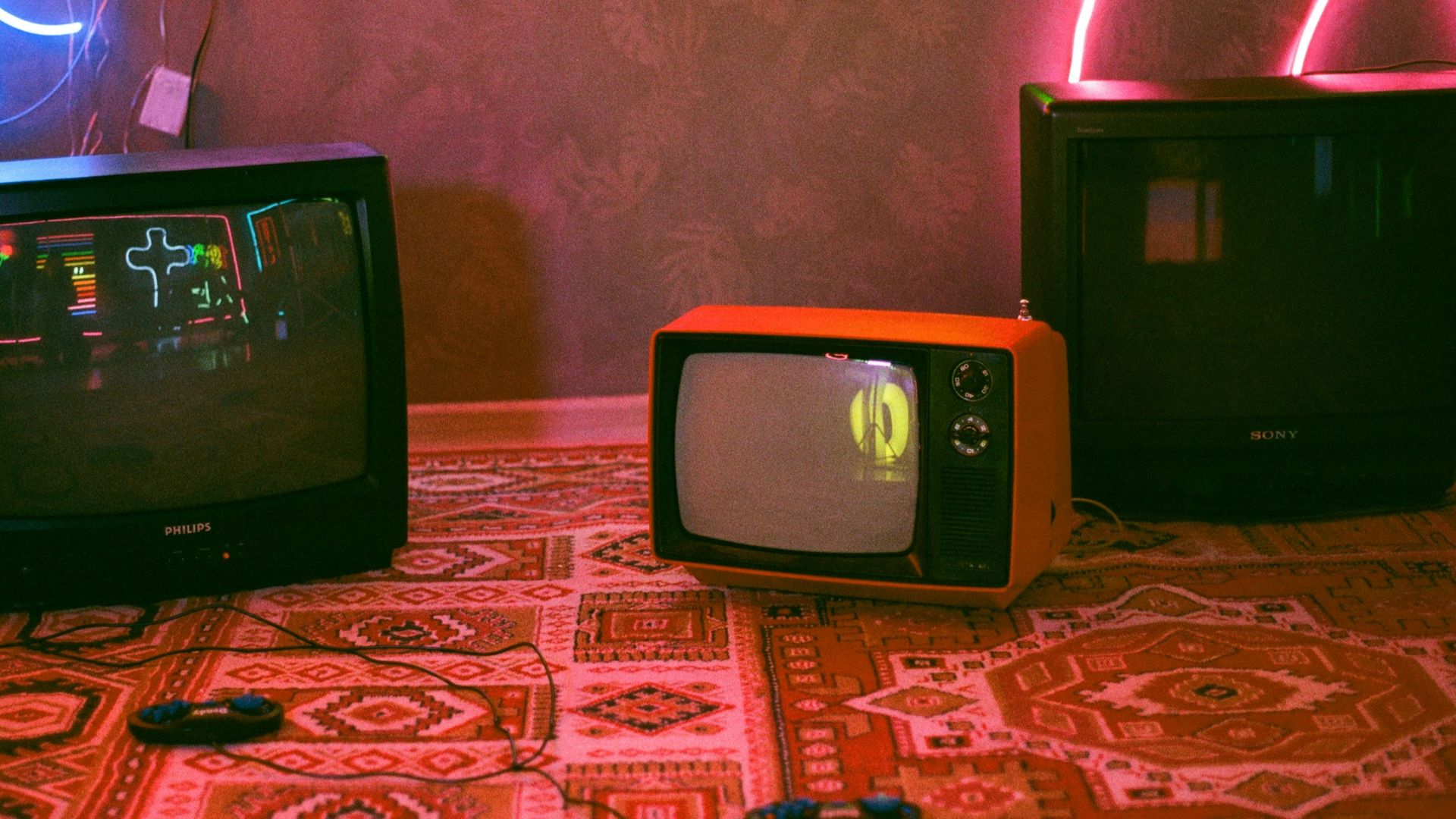 black crt tv on red and white floral textile