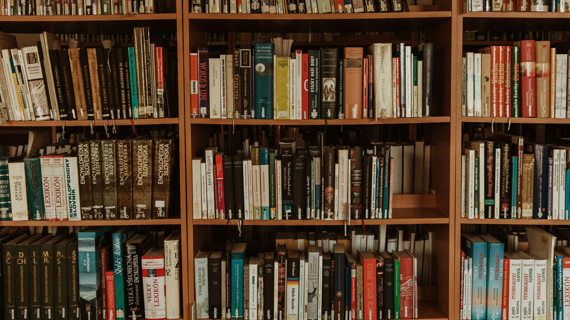 brown wooden book shelf with books