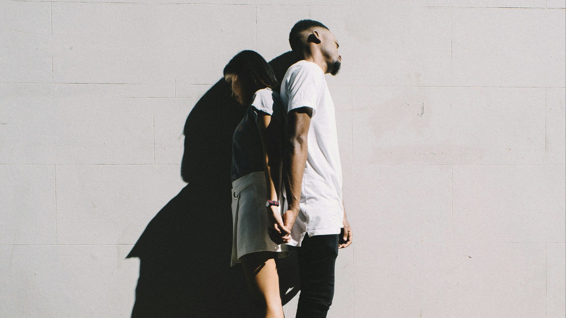 couple leaning on wall