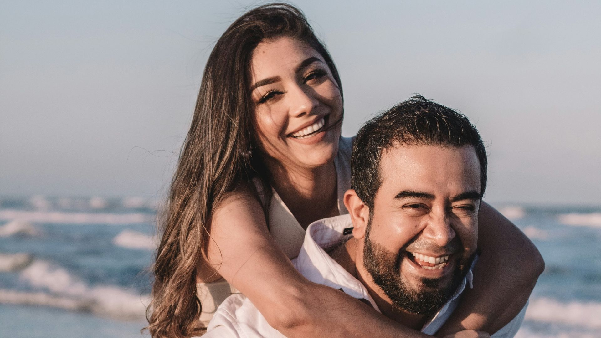 man in white dress shirt hugging woman in white dress