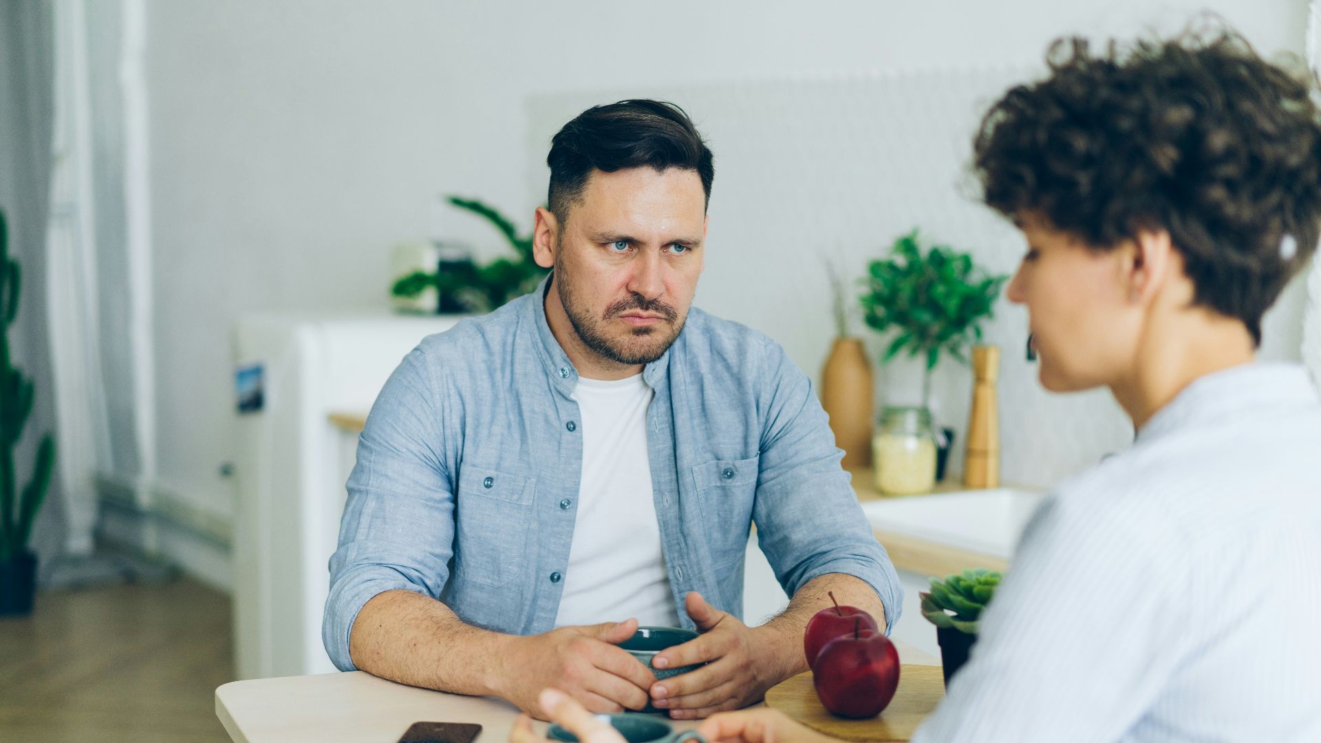 a man sitting at a table talking to a woman