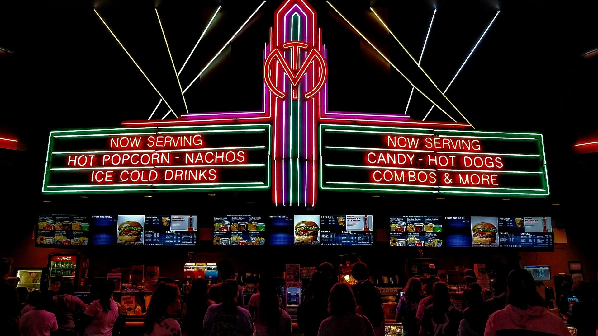 a crowd of people standing in front of a neon sign