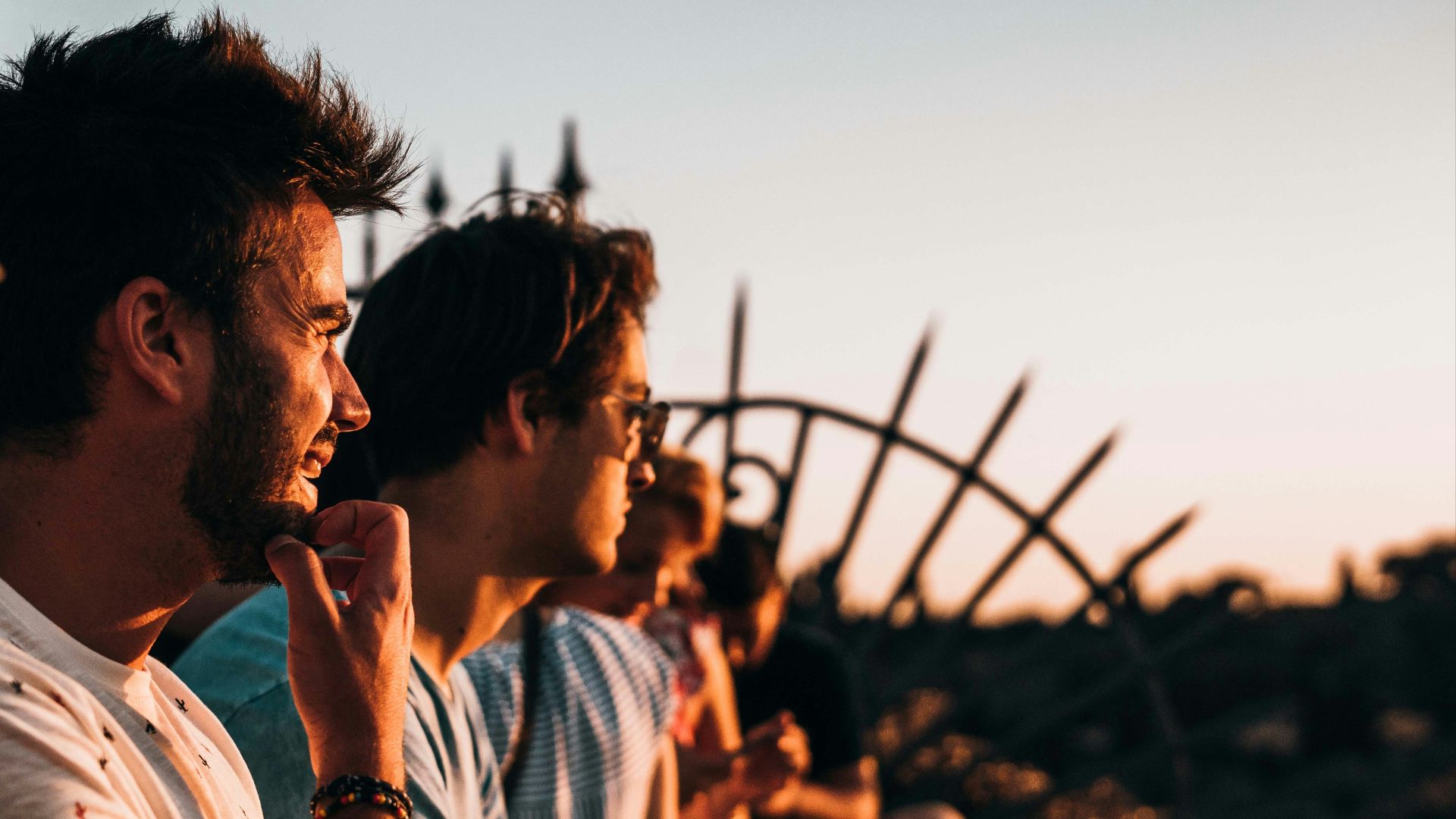 man sitting on fence facing right way under golden hour