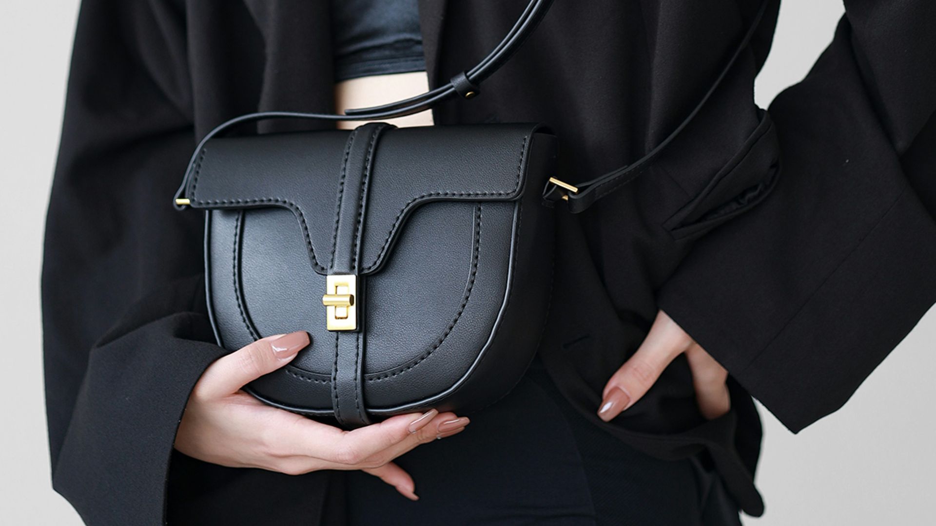 Woman in black blazer holding a black handbag
