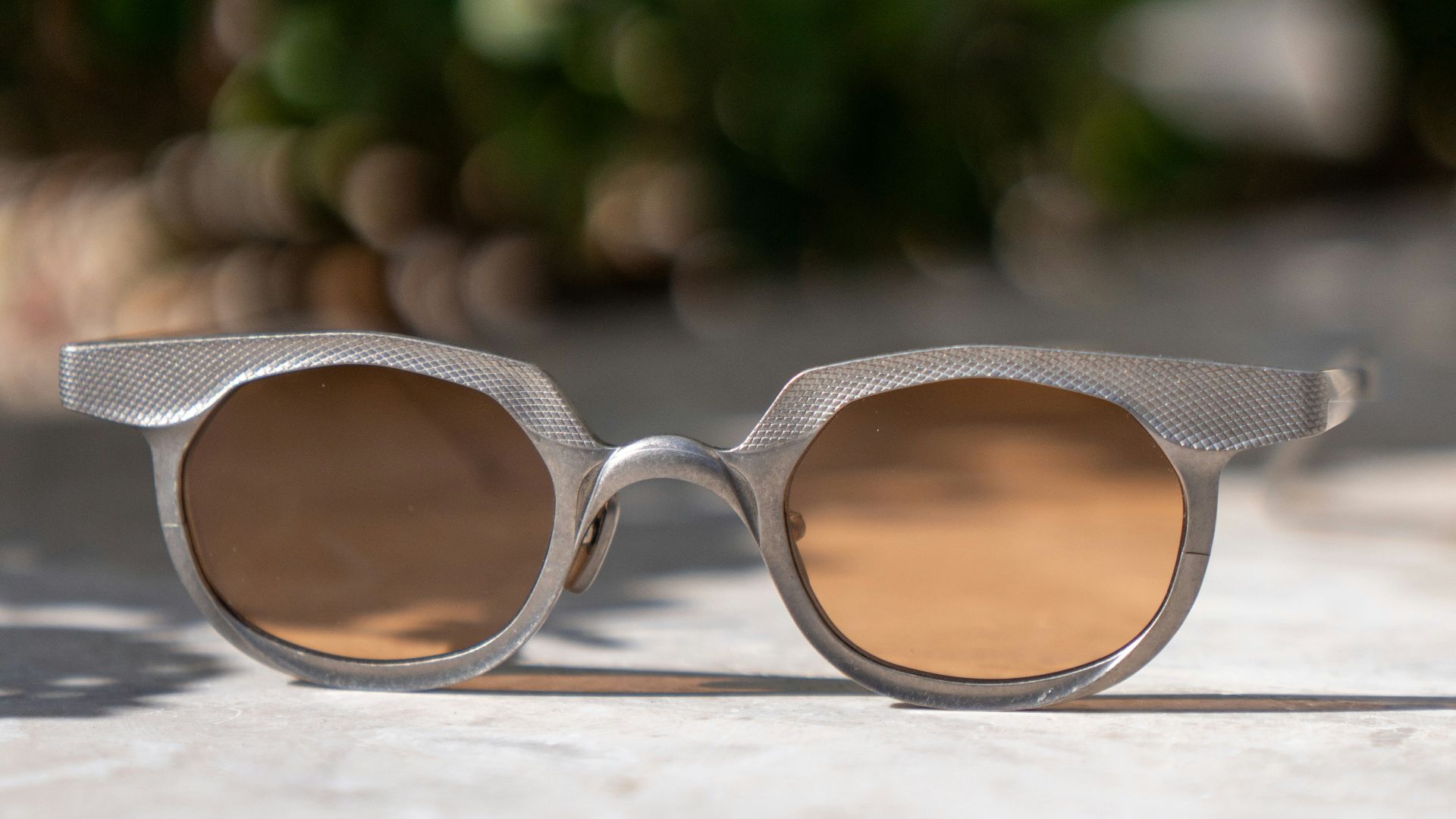A pair of sunglasses sitting on top of a cement ground