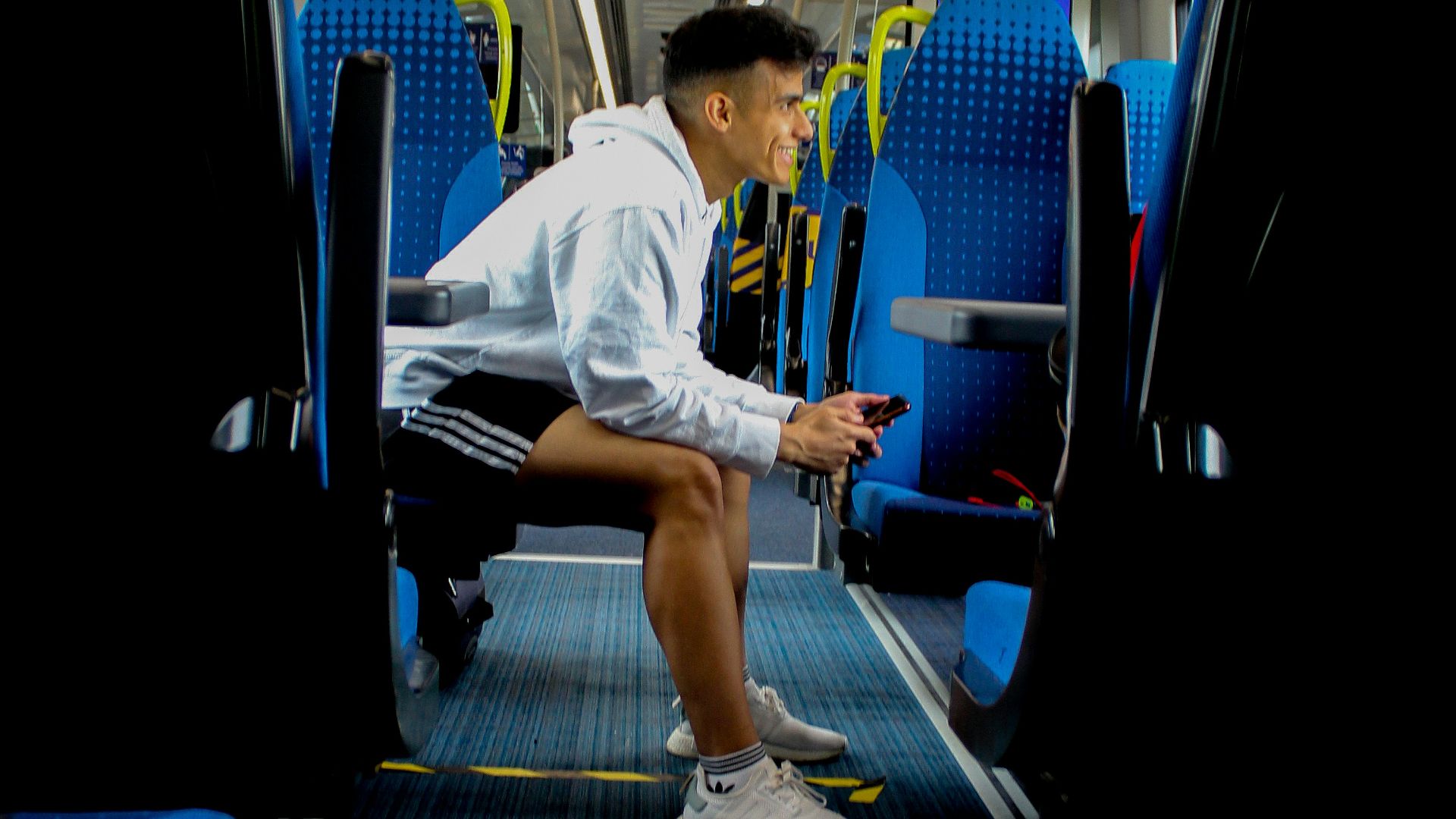 man in white t-shirt sitting on blue train seat