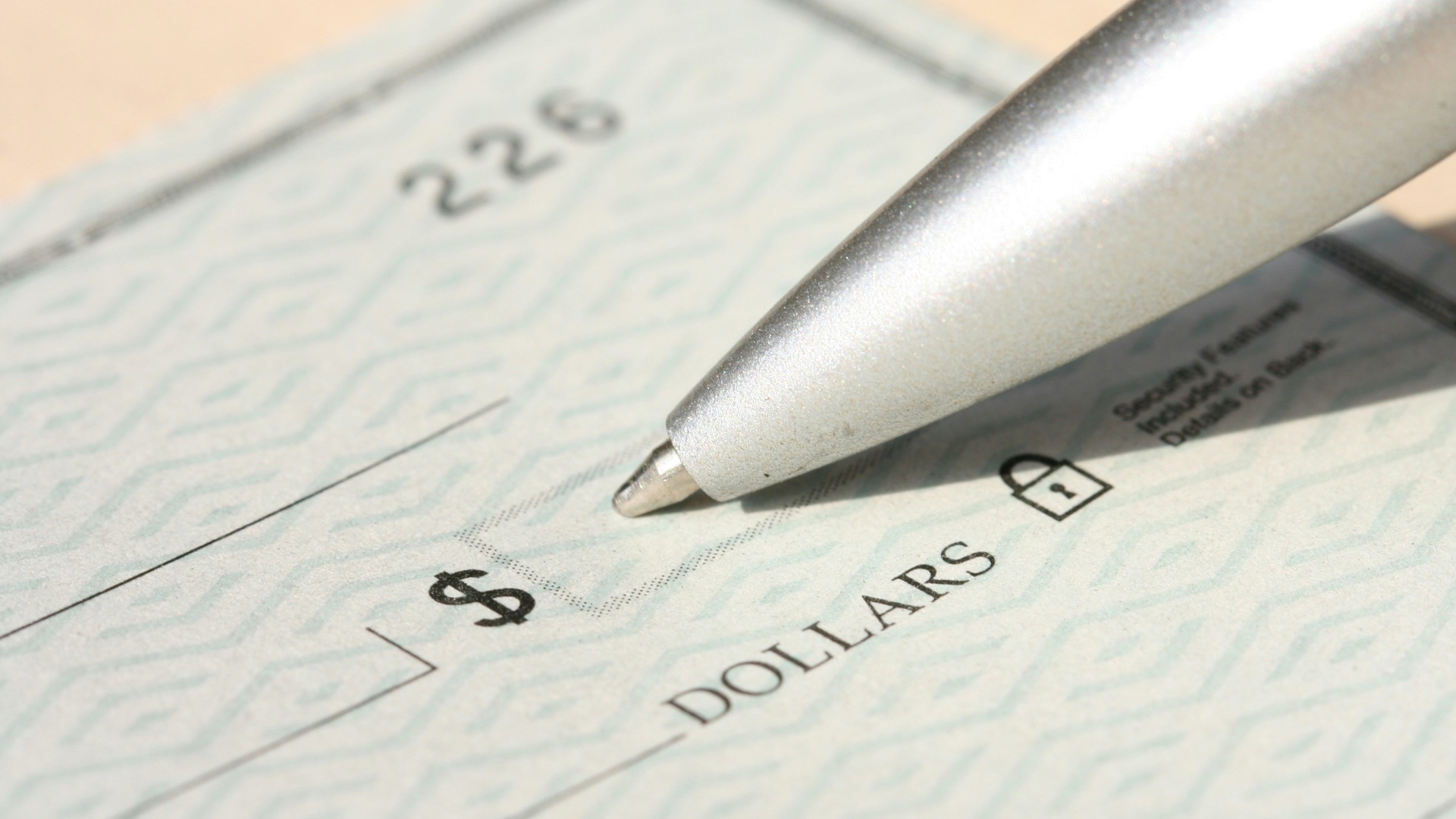 Pen poised over a check, ready to write.