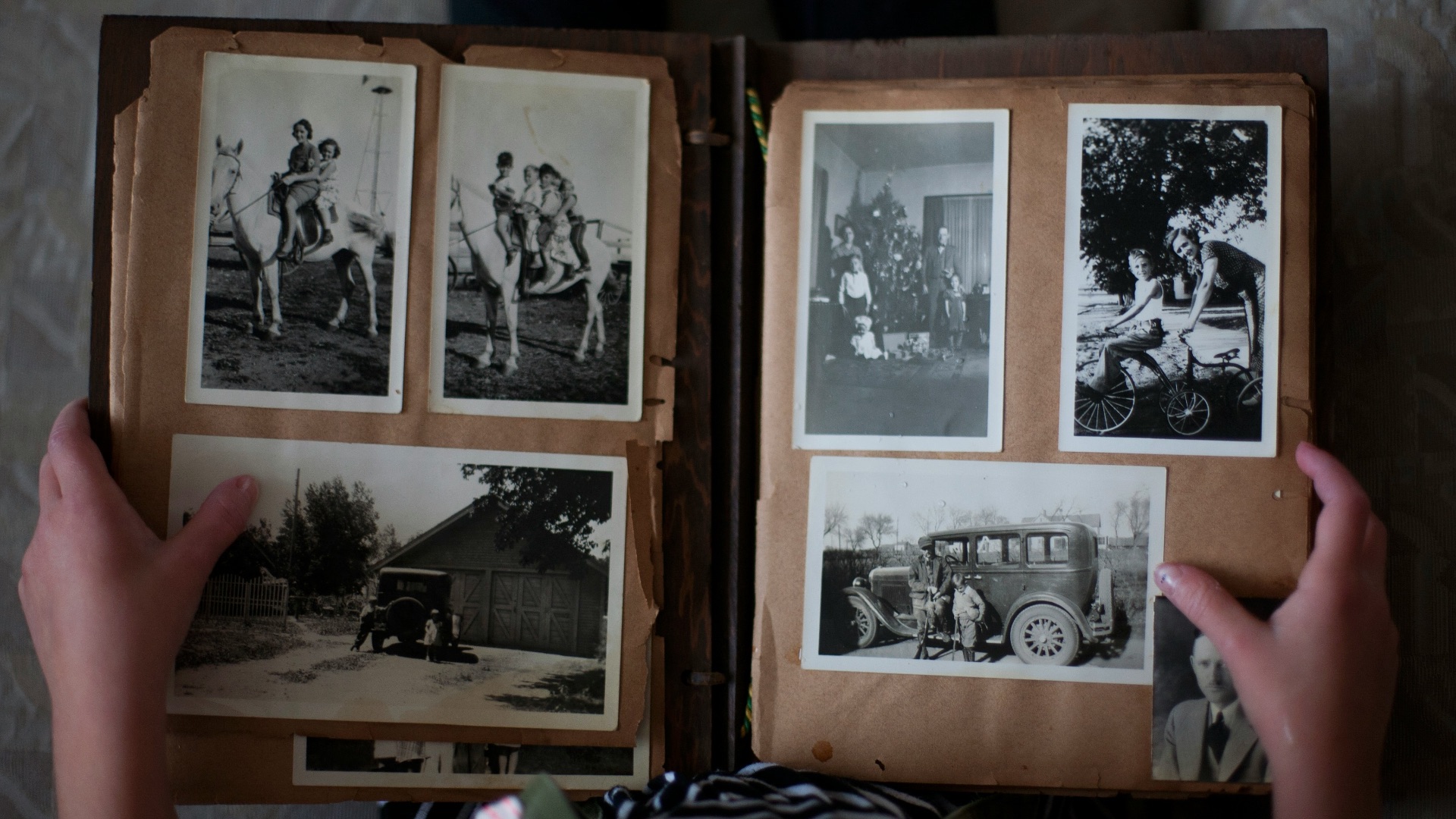 person opening photo album displaying grayscale photos
