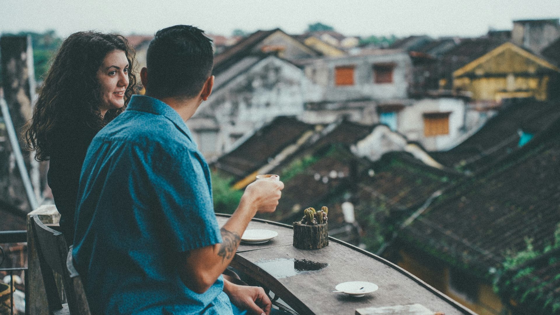 Couple enjoying coffee overlooking old town rooftops