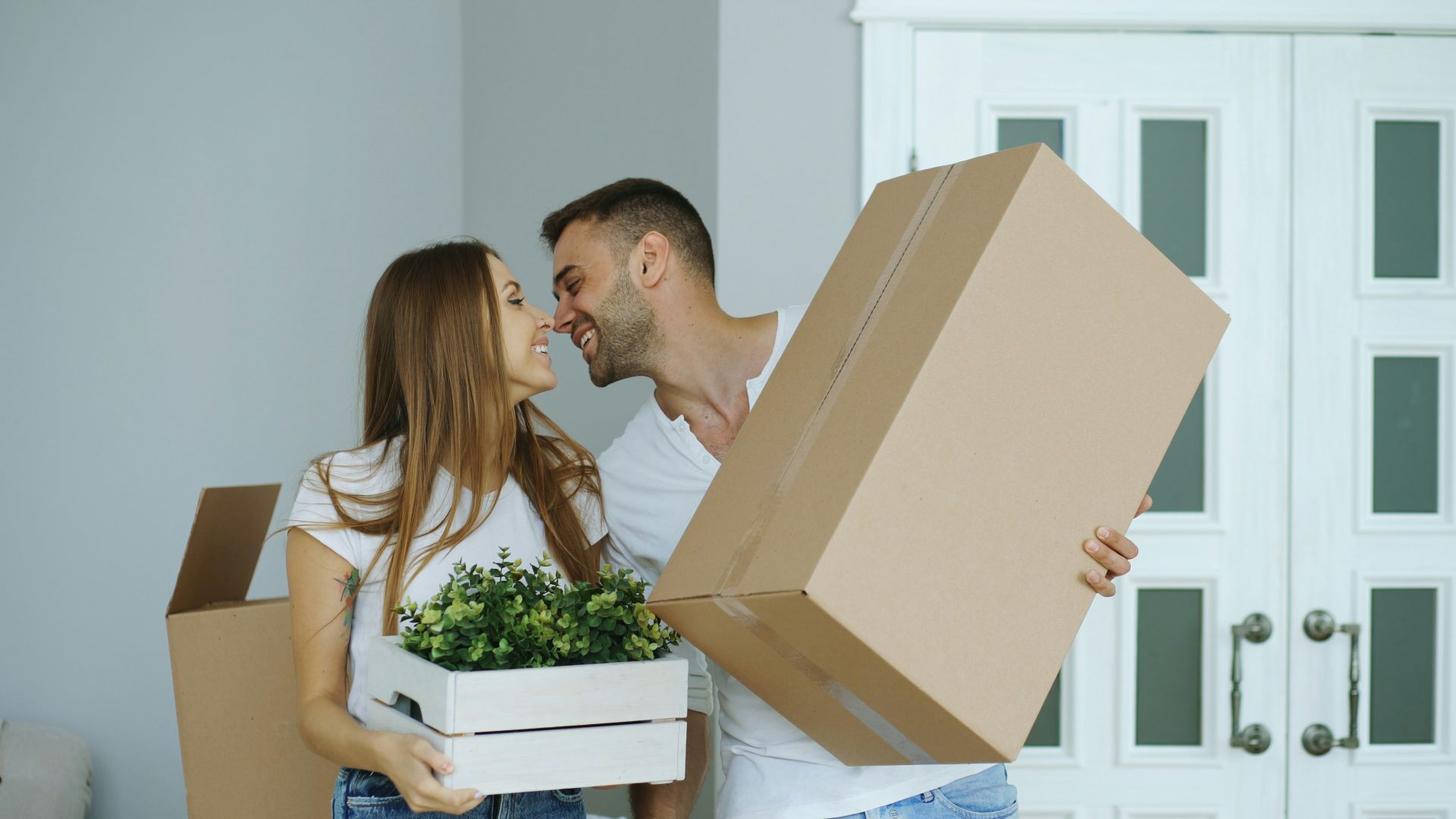 Couple holding boxes, ready to move