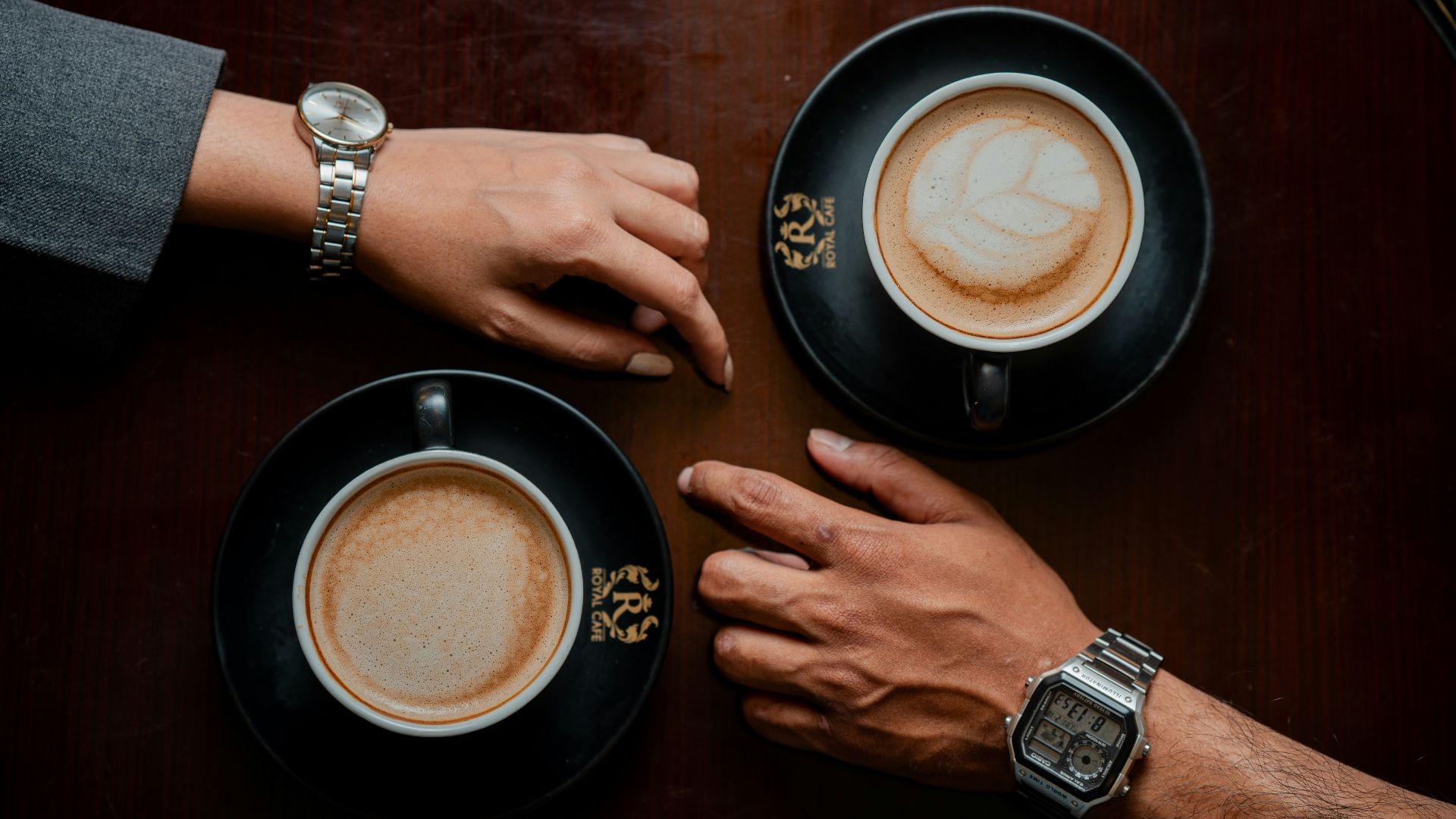 A couple of people sitting at a table with cups of coffee