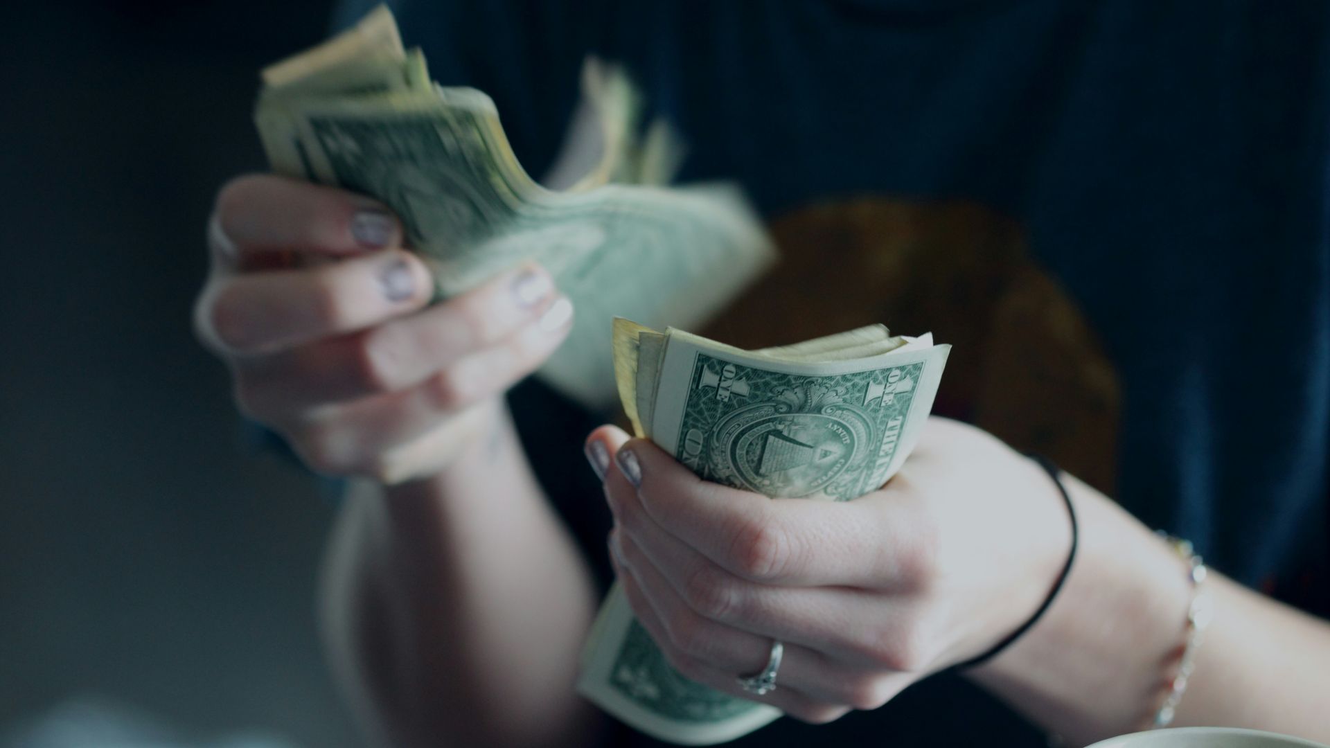 focus photography of person counting dollar banknotes