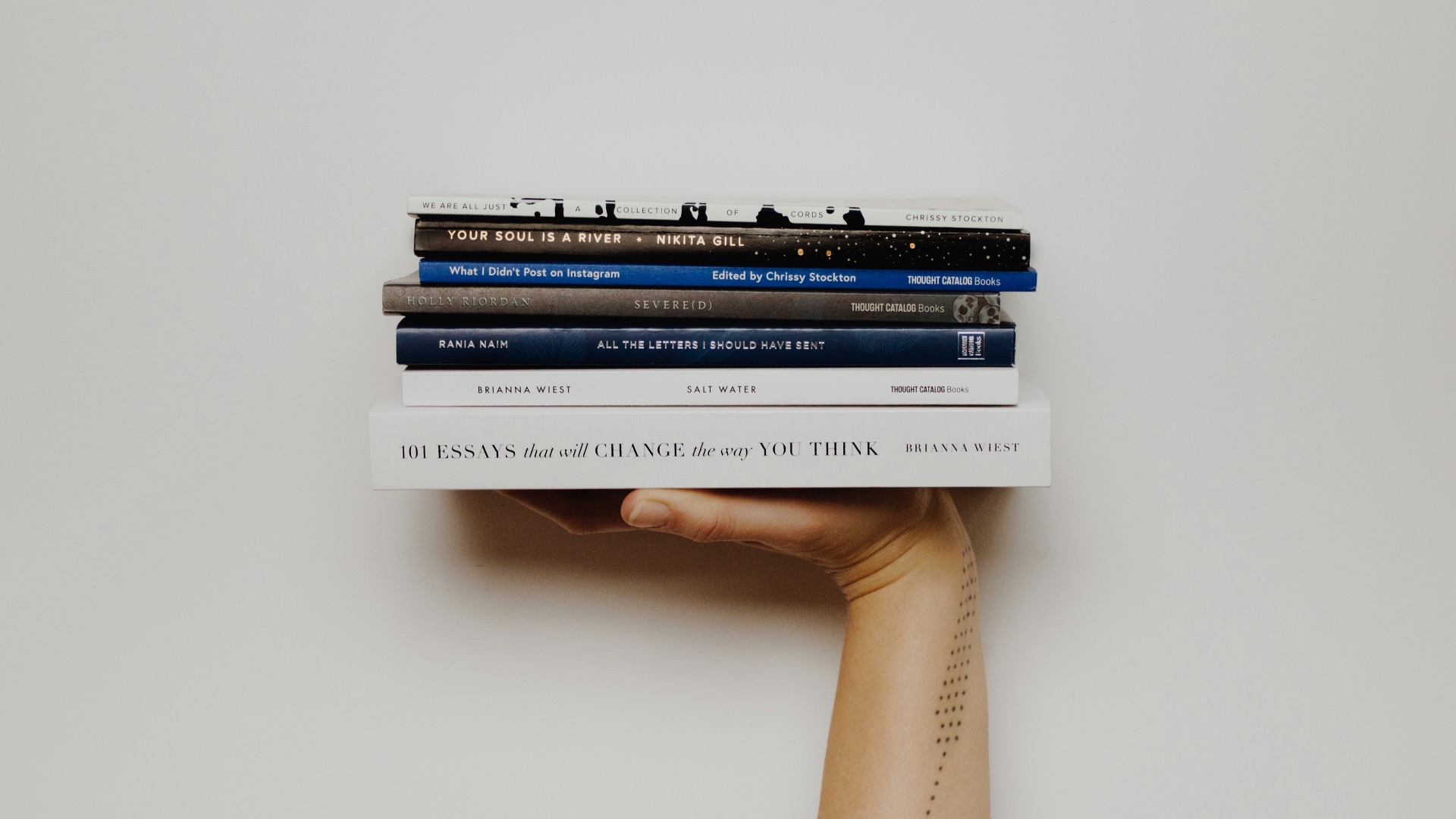 person holding pile of books