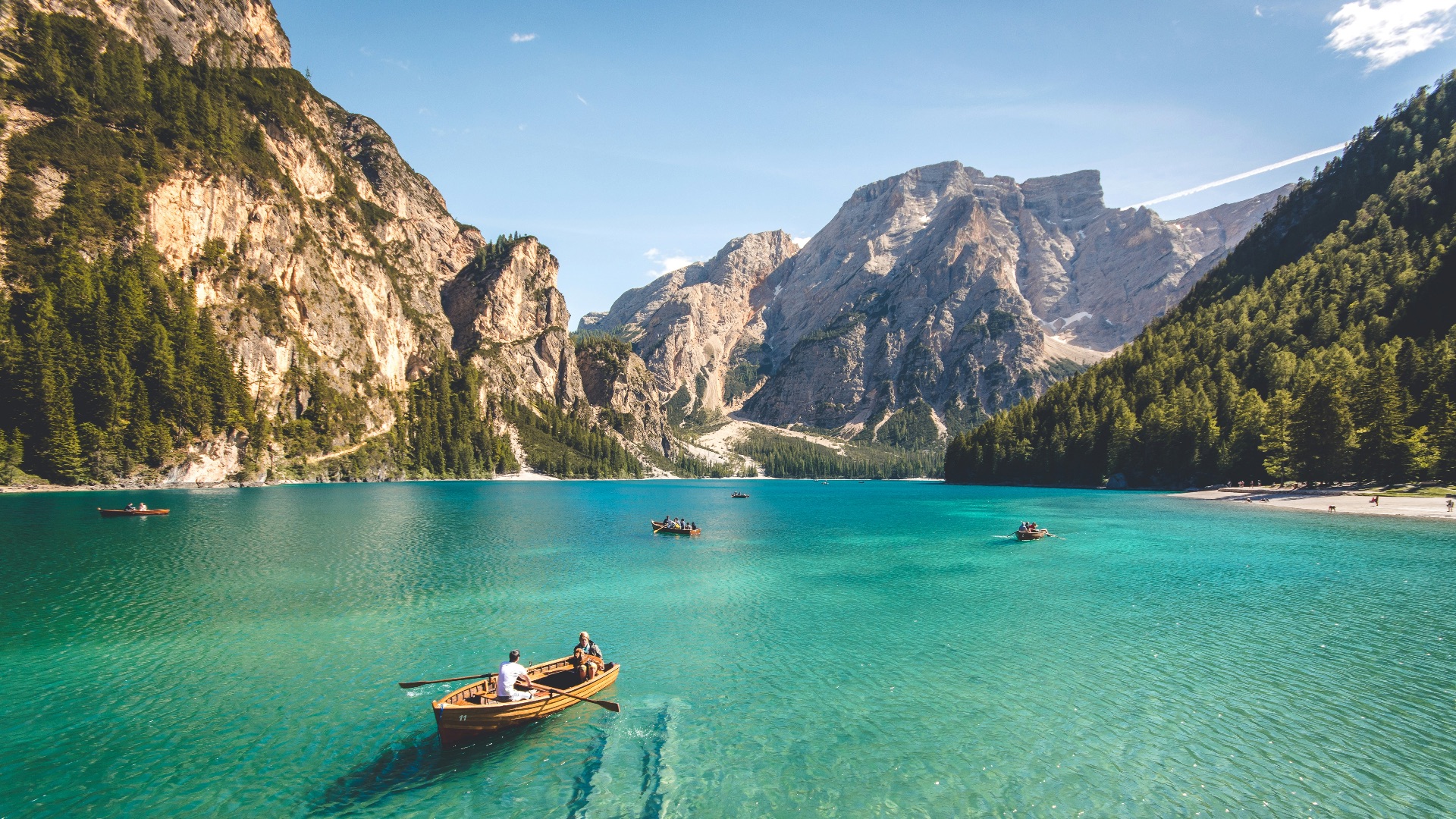 three brown wooden boat on blue lake water taken at daytime