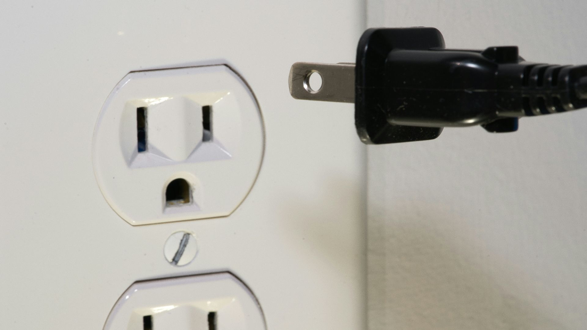 black male plug in front of electric socket