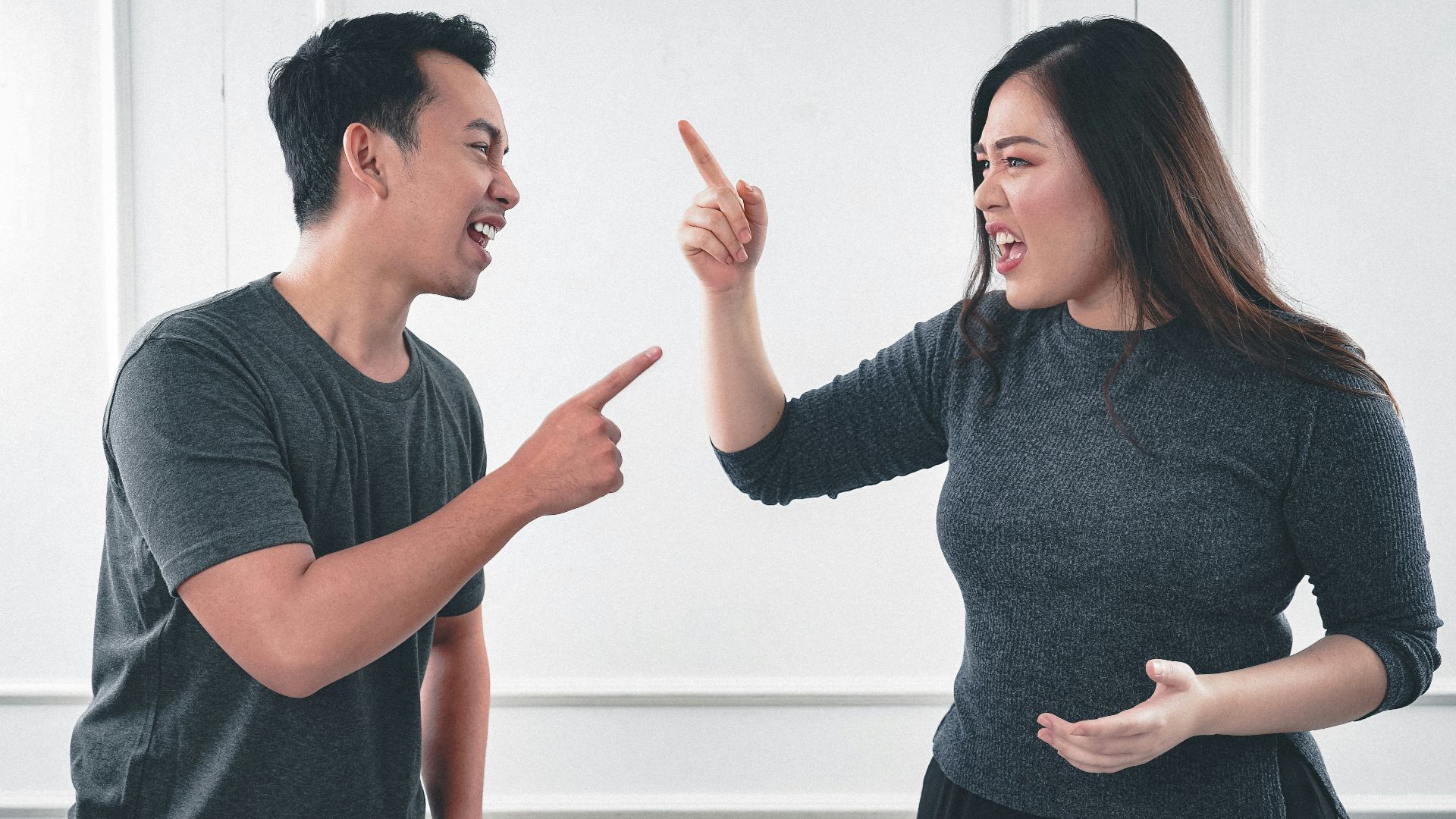 man in gray crew neck long sleeve shirt standing beside woman in black crew neck shirt